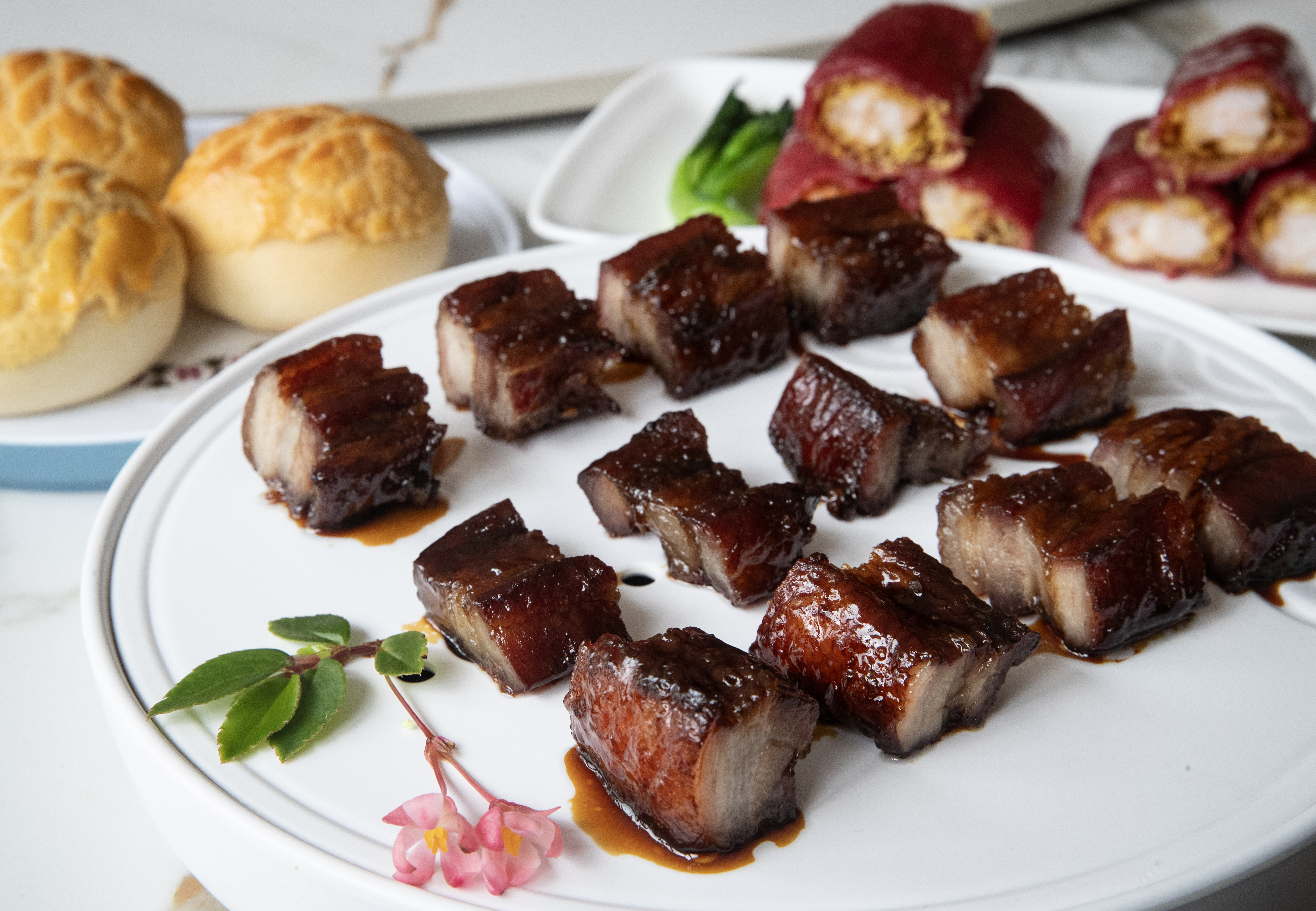 Sum Made secret recipe black barbecue pork with steamed red rice roll stuffed with crispy prawn and pineapple custard bun. Photo / Jason Oxenham