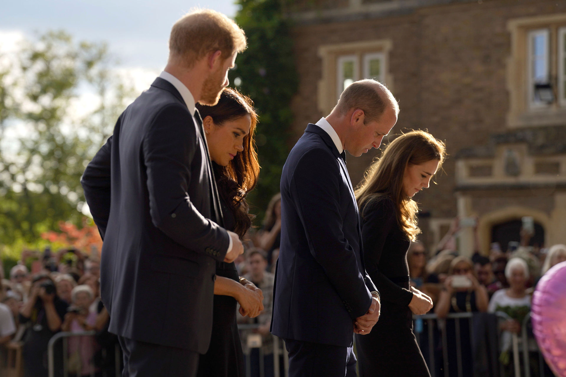 Prince Harry, Meghan, Duchess of Sussex, Prince William, Prince of Wales and Kate, Princess of Wales look at floral tributes as they meet members of the public at Windsor Castle. Photo / AP