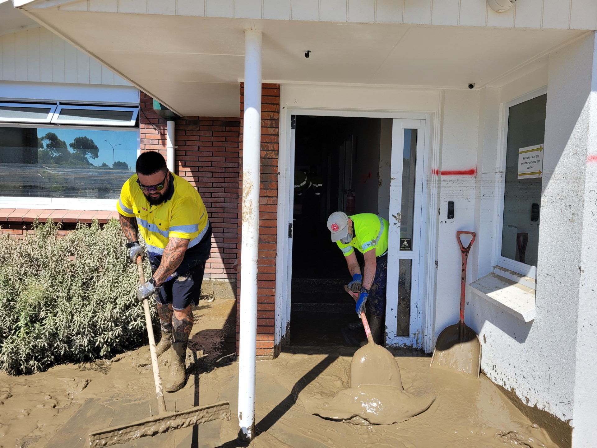Pan Pac staff cleaning out silt from the site's security building.