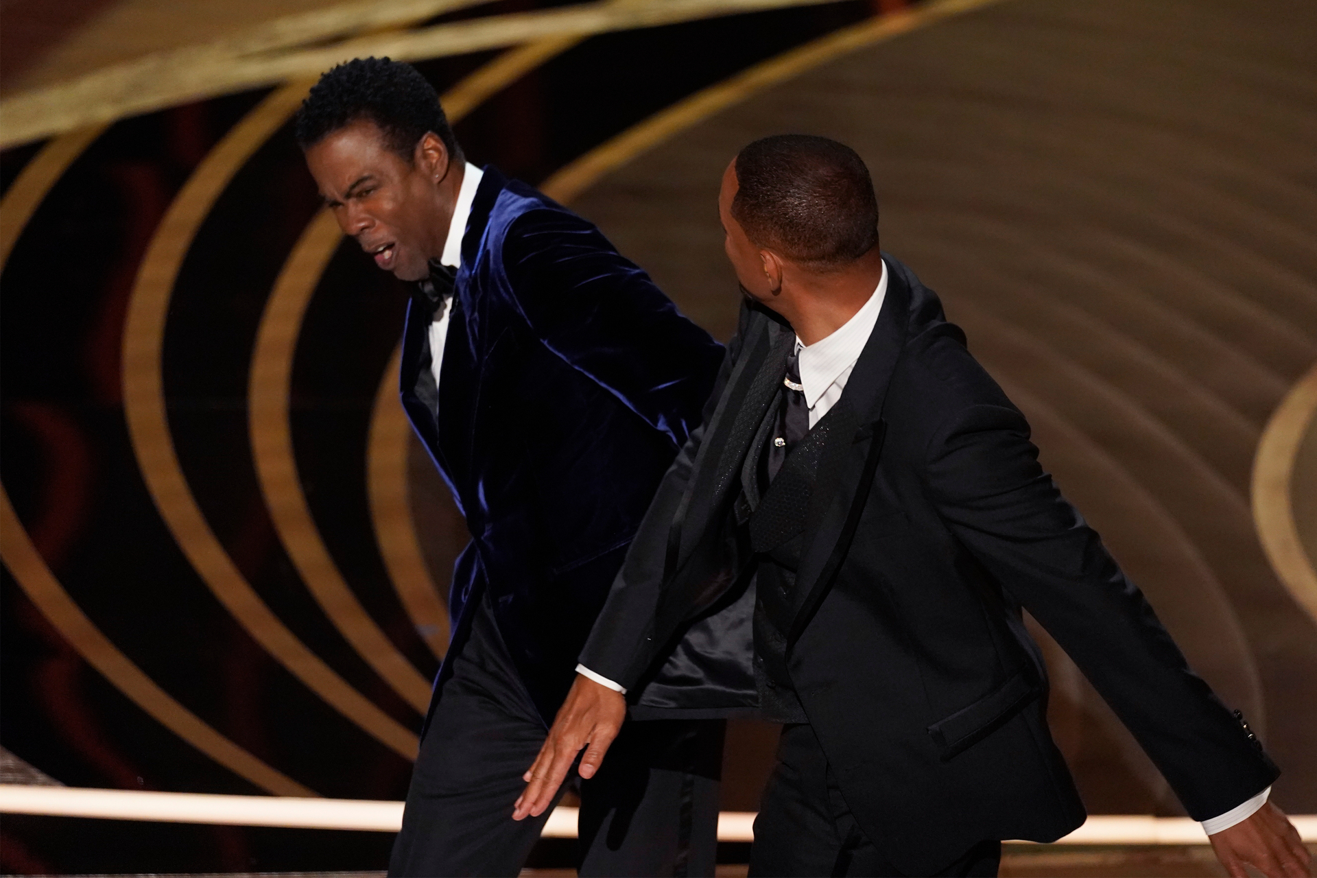 Will Smith, right, hits presenter Chris Rock on stage while presenting the award for best documentary feature at the Oscars. Photo / Chris Pizzello, AP