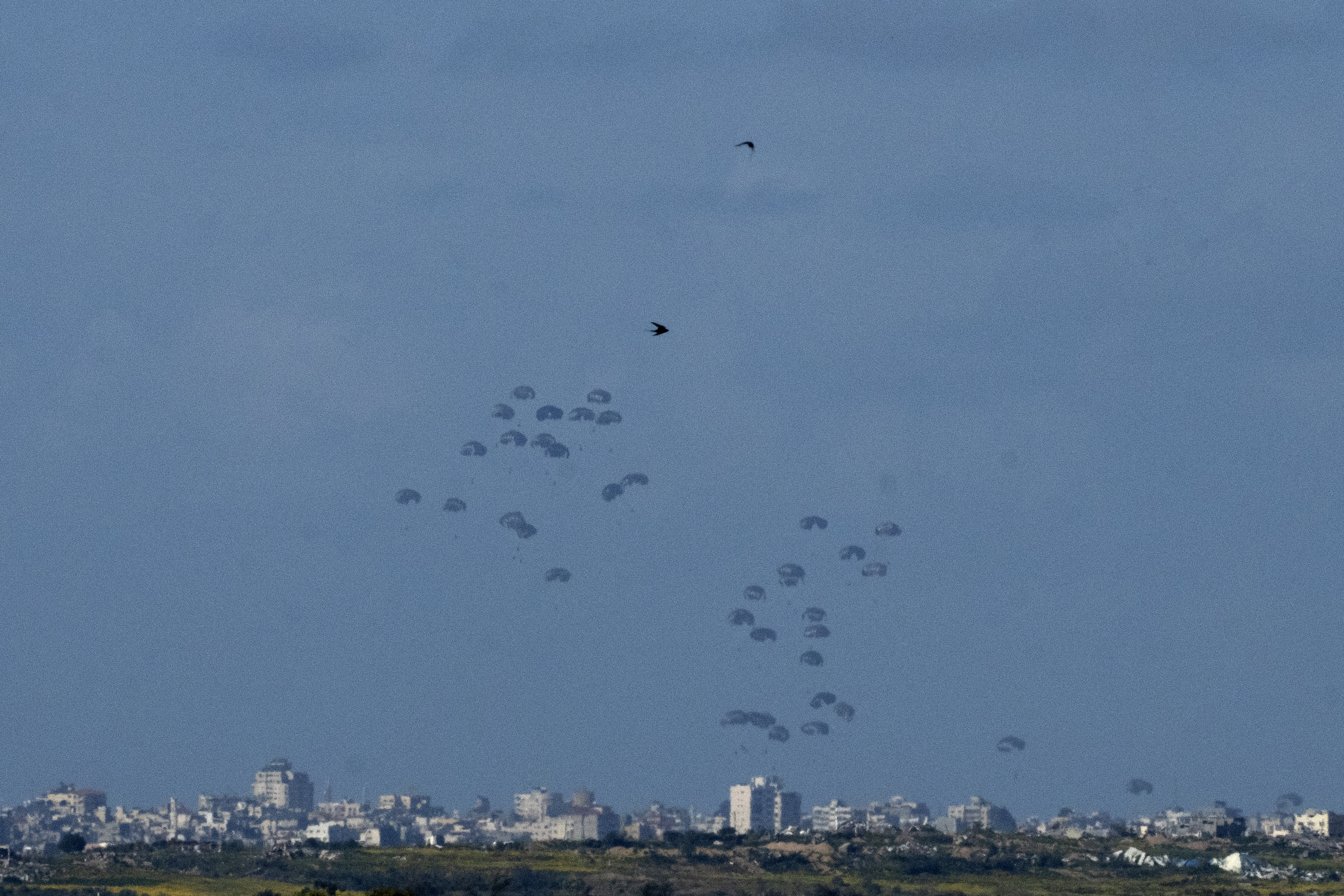 Parachutes drop supplies into the northern Gaza Strip on Thursday. Photo / AP 