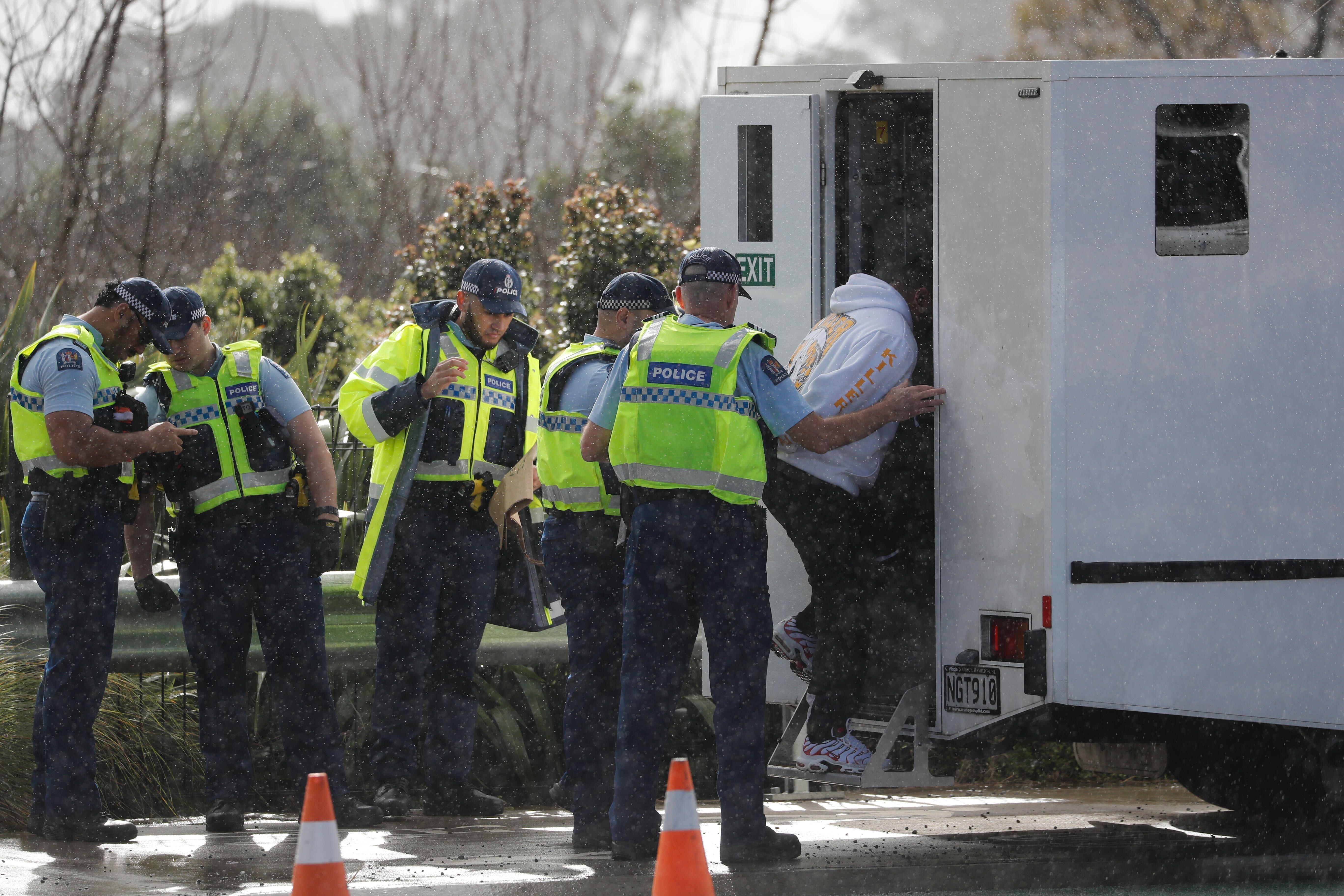 A Killer Beez gang member is taken into custody during the police operation at a gang tangi in Auckland. Photo / NZME