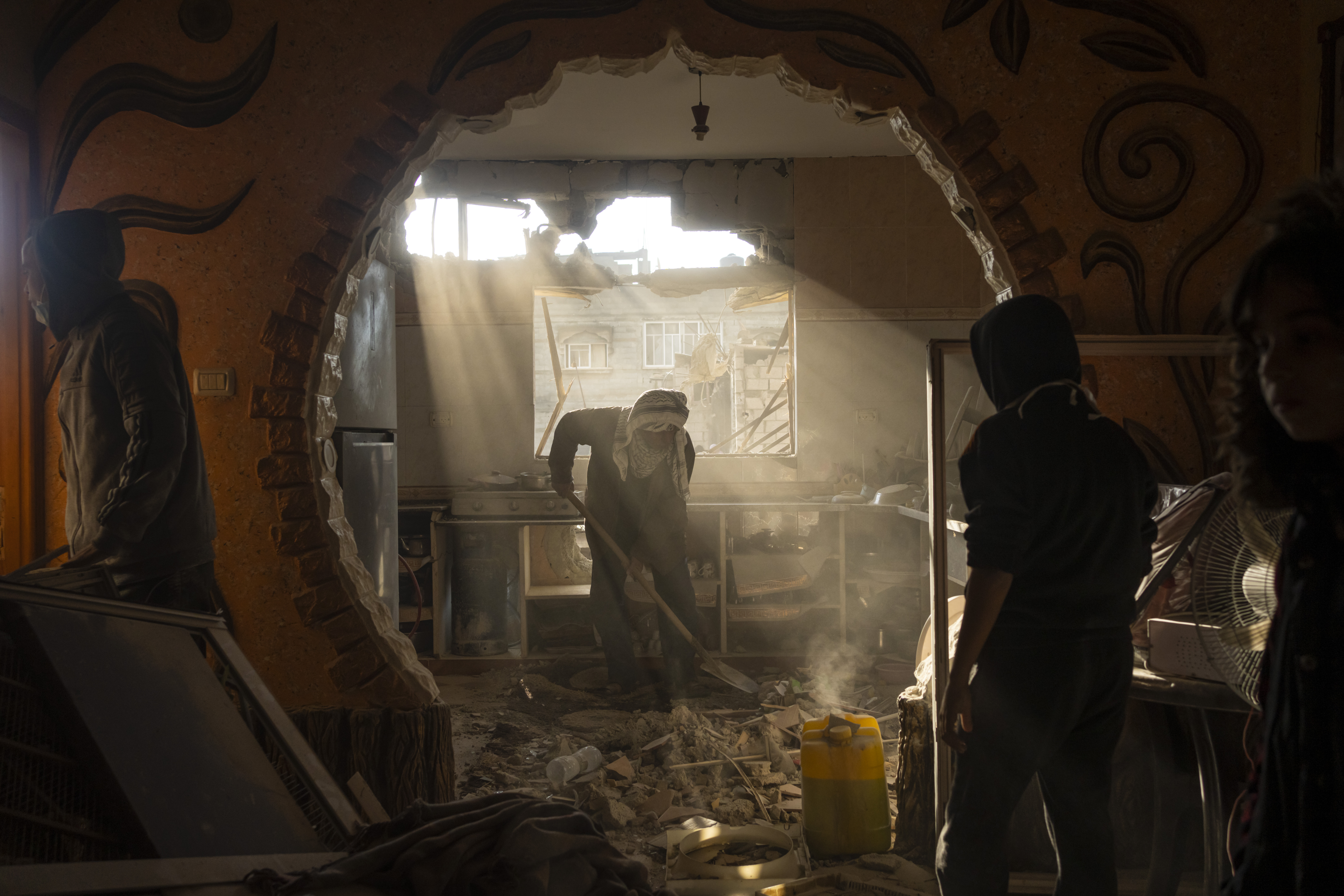 Palestinians look at their neighbour's damaged house following an Israeli strike in Rafah, southern Gaza Strip. Photo / AP