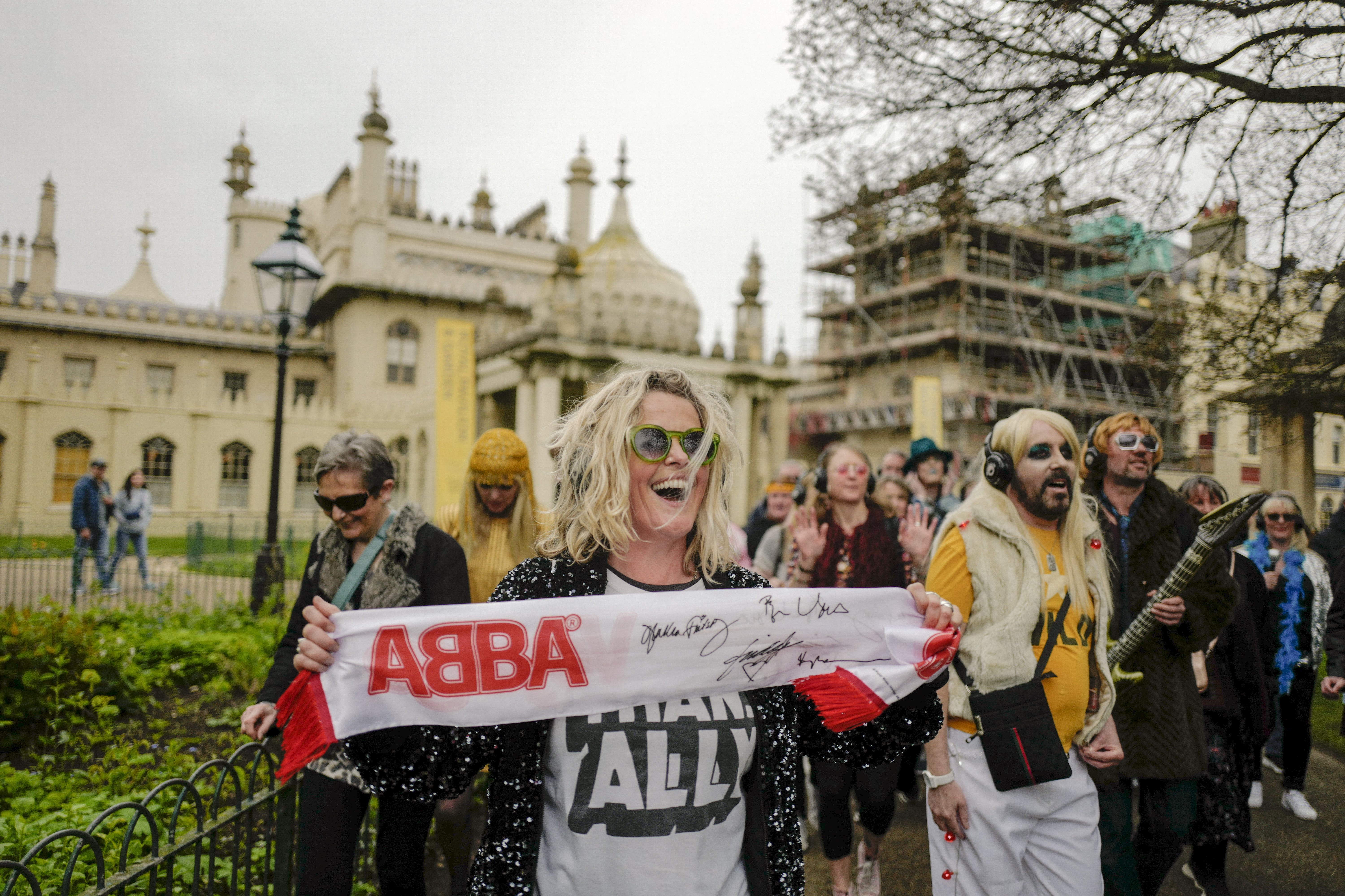 A woman holds an ABBA scarf, during a silent disco event outside the Brighton Dome, in Brighton. Photo / AP