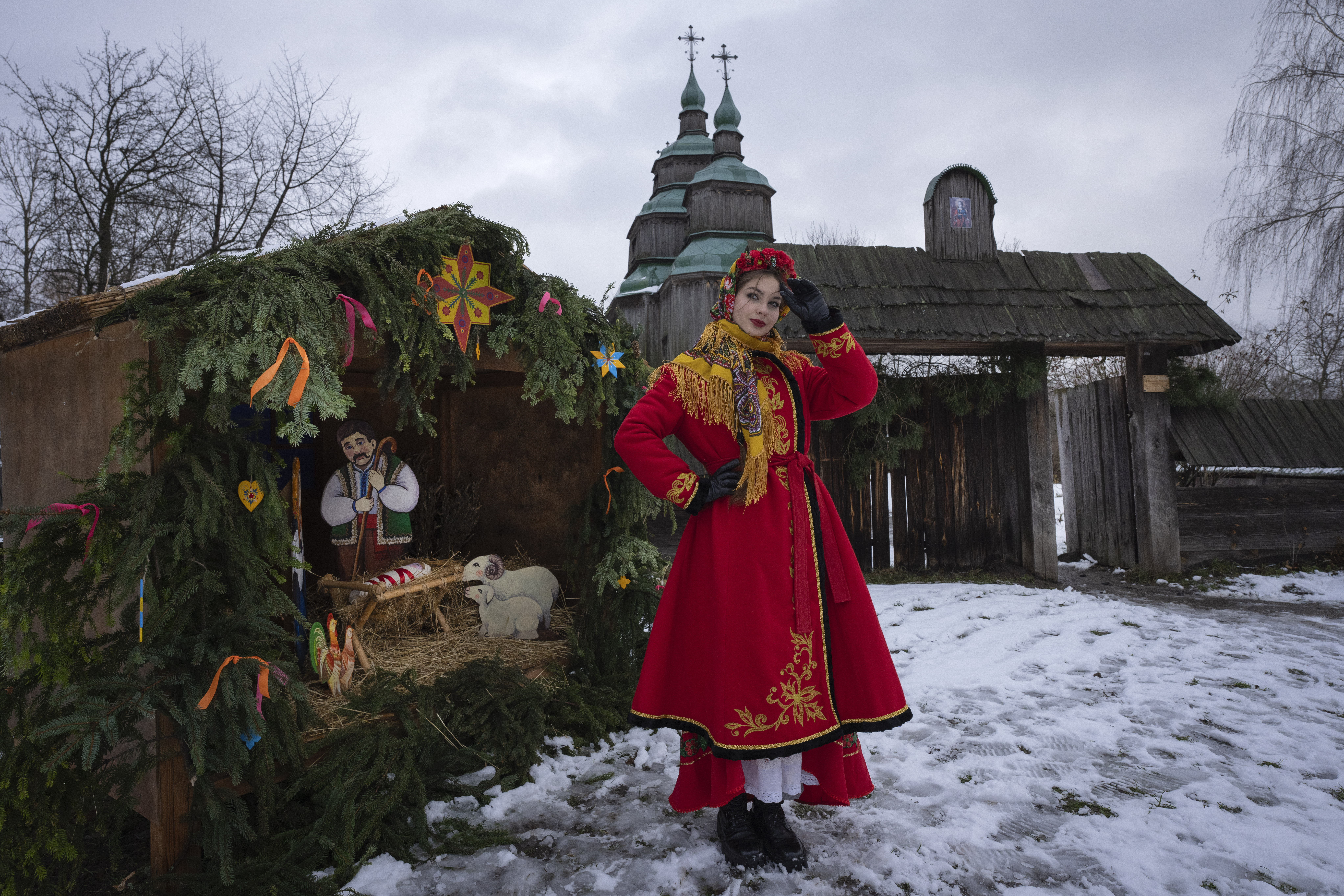 A woman dressed in national costume stands near the nativity scene to celebrate Christmas in the village of Pirogovo, outside the capital Kyiv, Ukraine. Photo / AP