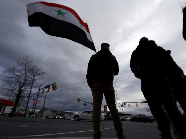 A man holds a Syrian flag during a rally in opposition to the US missile strikes in Syria in Allentown, Pennsylvania. Allentown has one of the nation's largest Syrian populations. They are mostly Christian and support Syrian President Bashar al-Assad. Photo/AP
