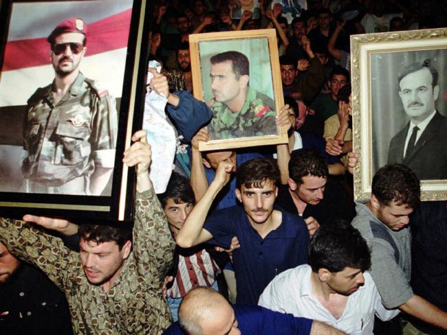 Syrians hold portraits of President Hafez Assad (right) son Bashar (centre) and son Bassel, following the President's death in 2000. Photo/AP