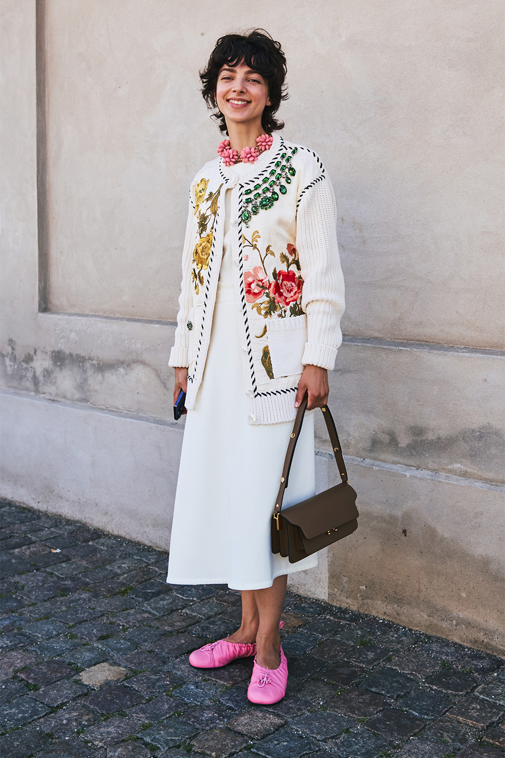 A simple white dress is styled with a floral cardigan. Photo / Simbarashe for The New York Times