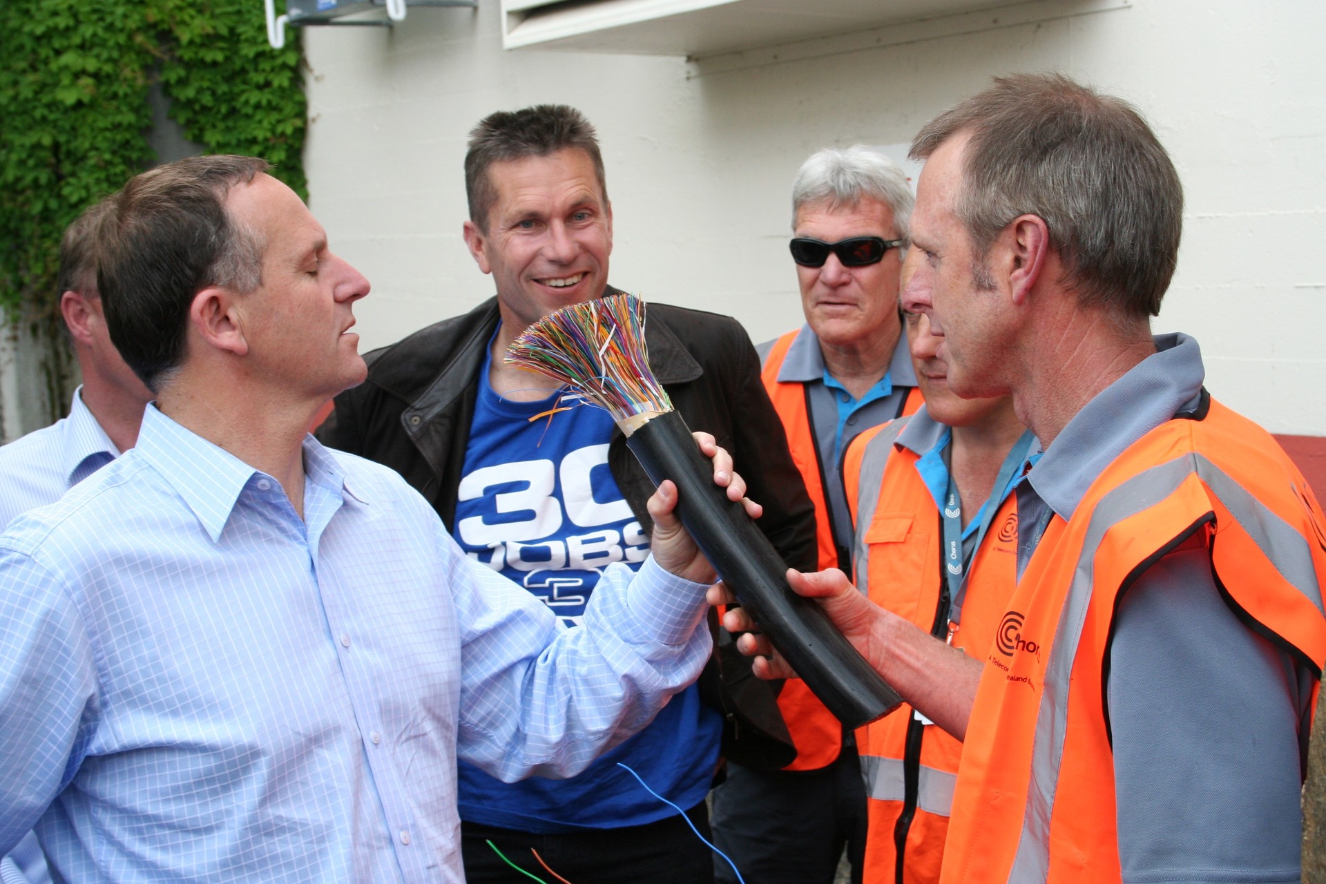Chorus Hawke's Bay regional UFB rollout manager Nick Van Druten shows Prime Minister at the time, John Key, one of the fibre cables being laid as part of the Government's ultra-fast broadband deployment in 2011. The Government is considering selling down the debt it holds from the UFB rollout. Photo / Patrick O'Sullivan
