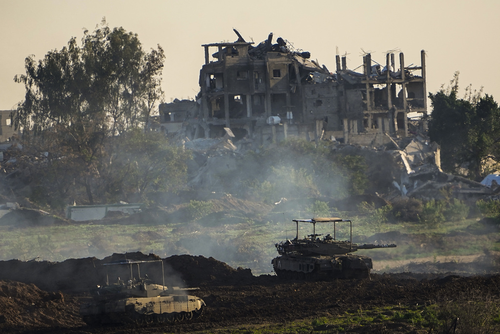 Israeli tanks are seen next to a destroyed building during a ground operation in the northern Gaza Strip. Photo / AP