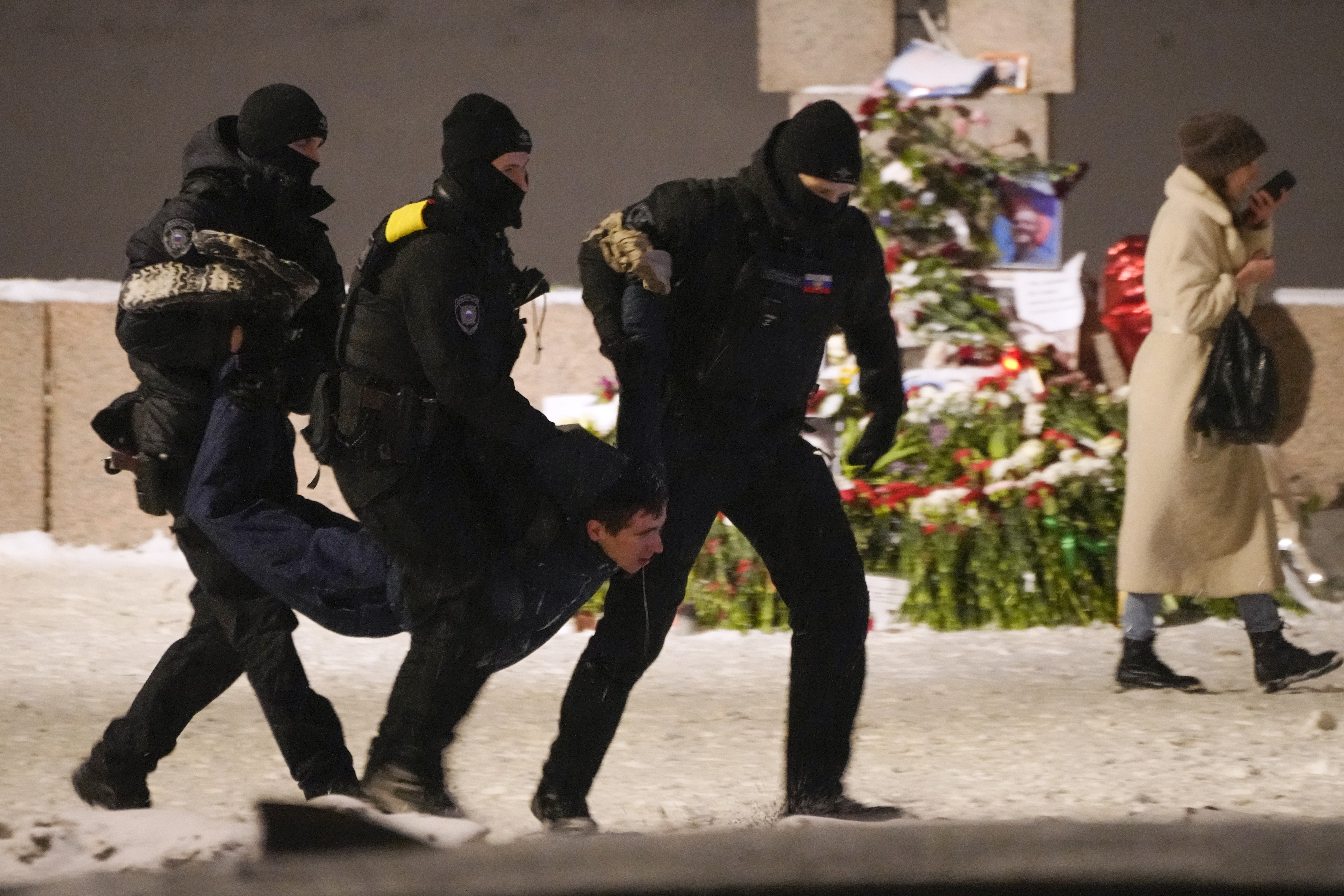 Police officers detain a man laying flowers to Alexei Navalny at the Memorial to Victims of Political Repression in St Petersburg, Russia. Photo / AP