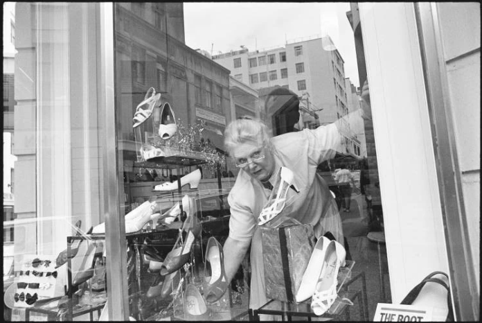 June Fletcher, store manager of Campbell’s Shoes, arranging shoes in the shop window, on the corner of Vulcan Lane and High Street, 1989. Photo / Auckland Libraries Heritage Collections 