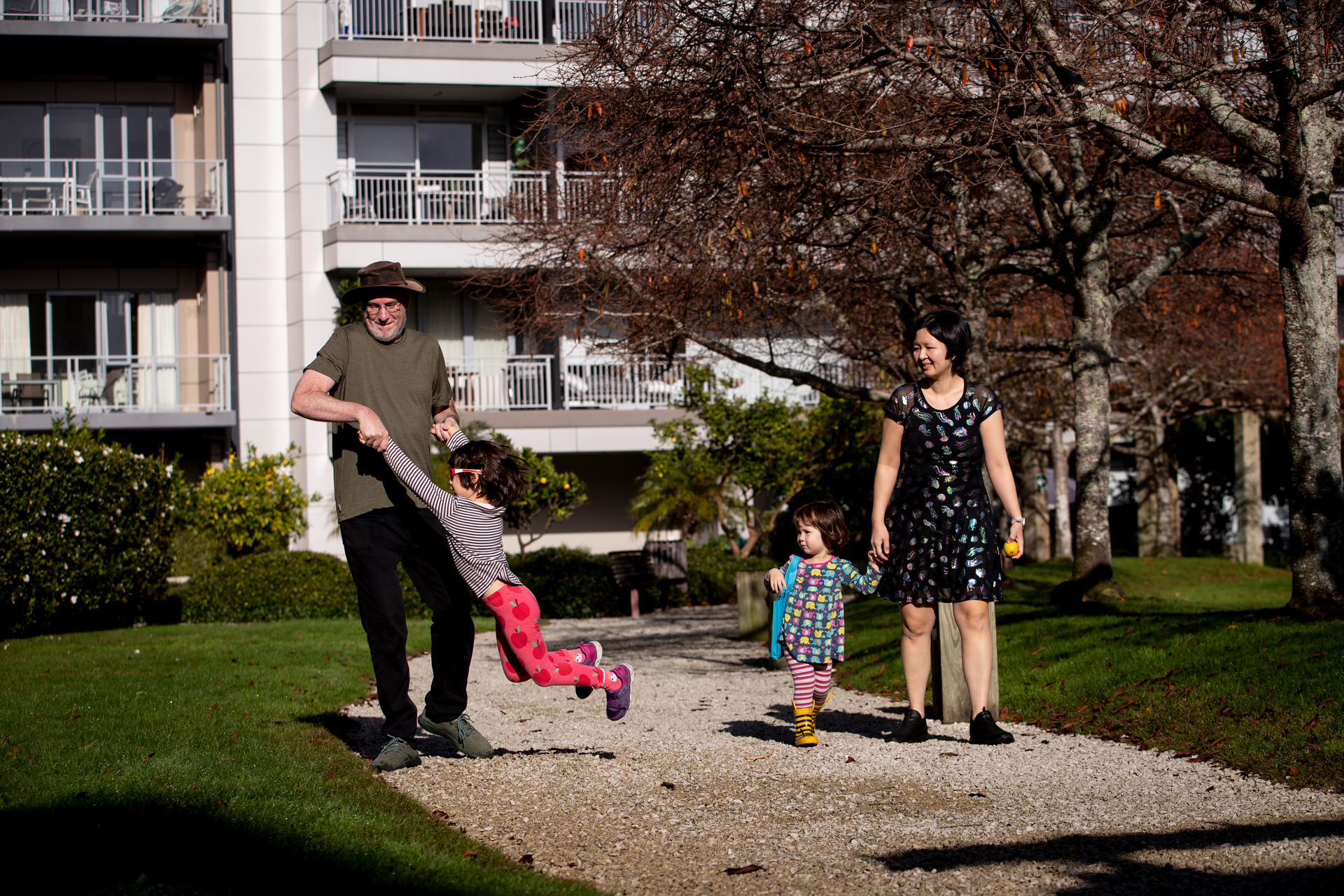The Wiggs/Khoo family love living in central Auckland. Pictured in the green space outside their apartment are Lance Wiggs, left, Ada Wiggs, 6, Edna Wiggs, 2, and Su Yin Khoo. Photo / Dean Purcell