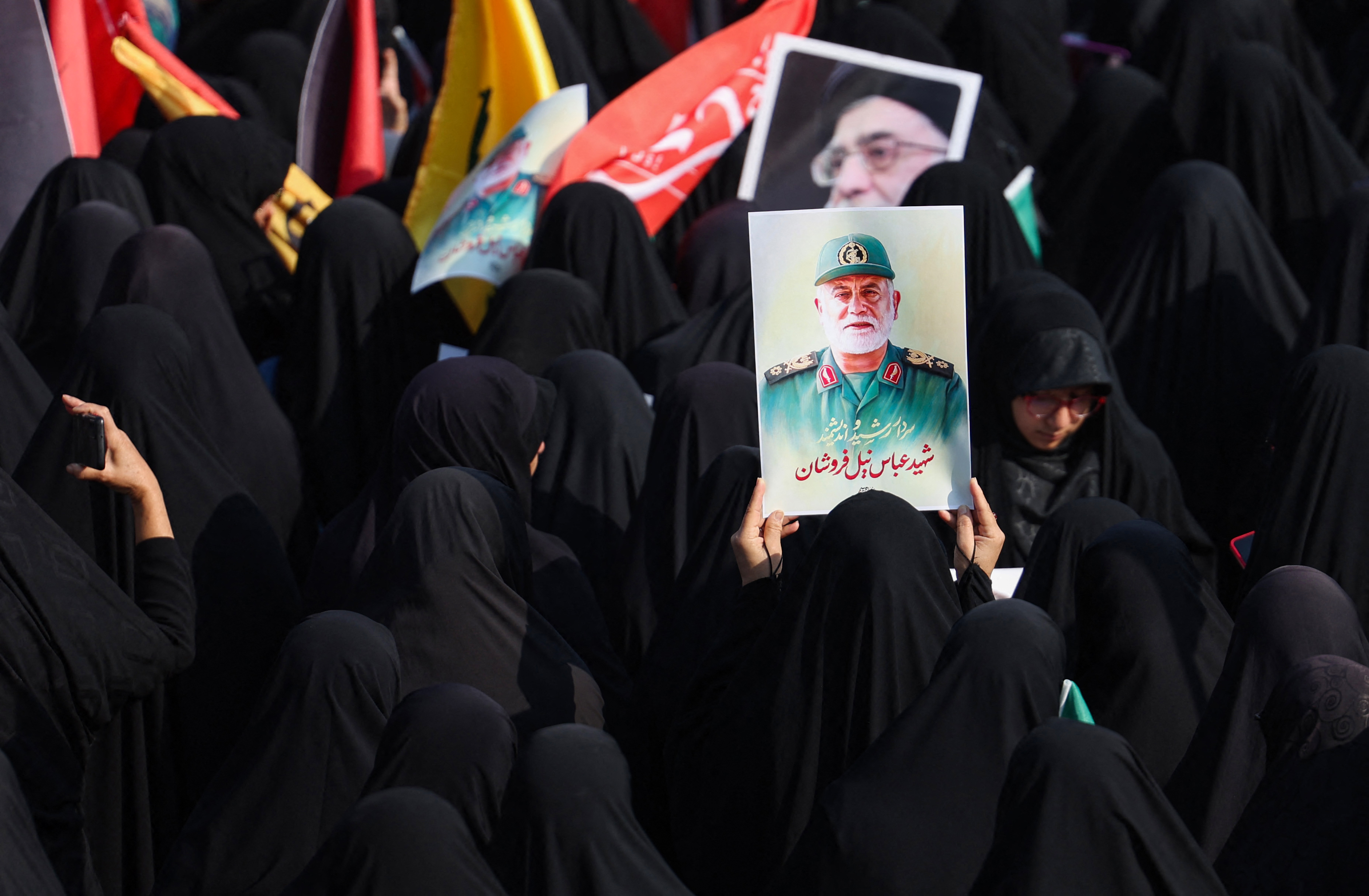 Women lift a portrait of Iran's Islamic Revolutionary Guards commander Abbas Nilforoushan during his funeral procession in Tehran on October 15, 2024. Photo / AFP