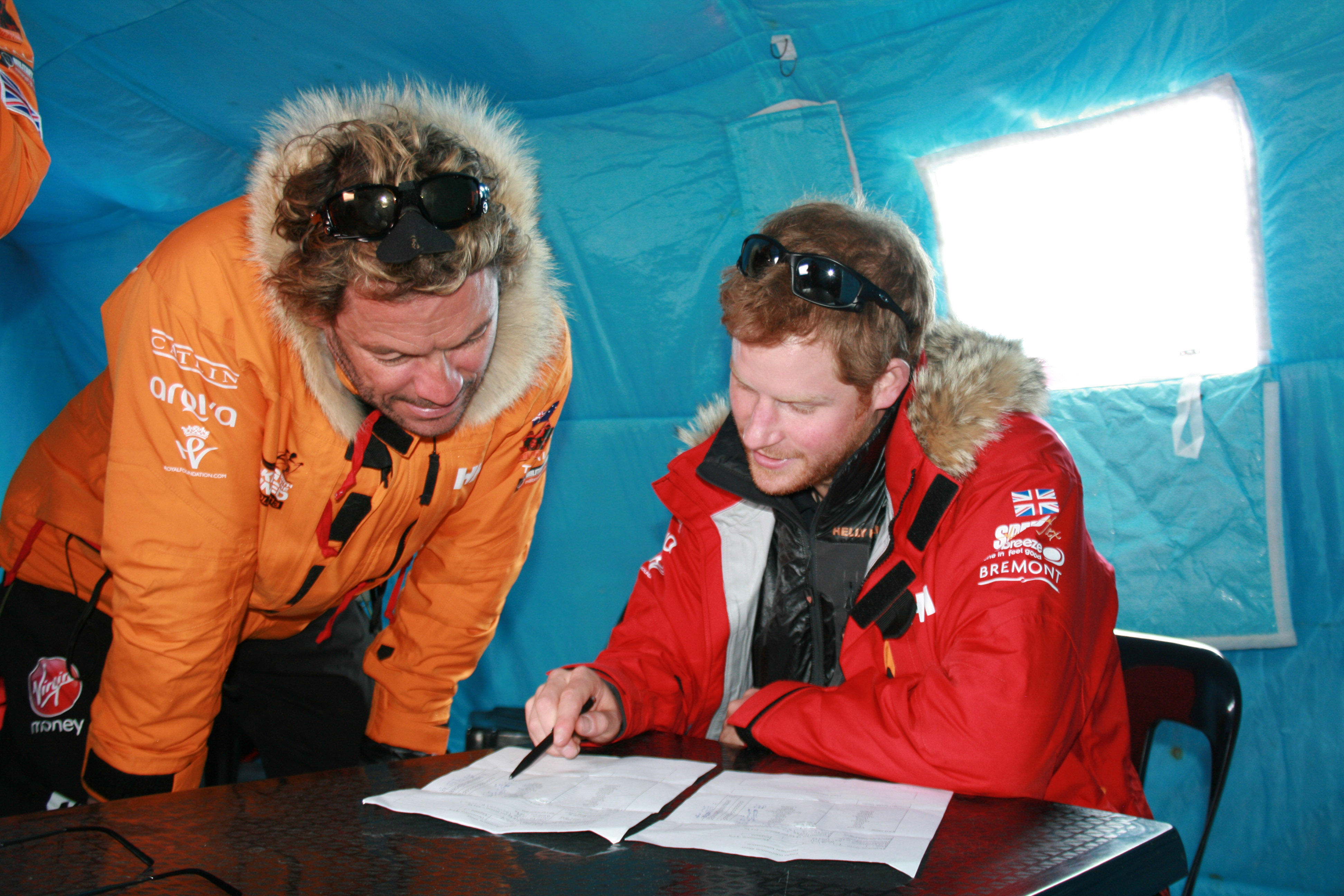 Prince Harry, patron of Team UK in the Virgin Money South Pole Allied Challenge 2013 expedition, and Dominic West make notes of how much each individual and their kit weighs, during preparations in Novo, Antarctica. Photo / Getty Images