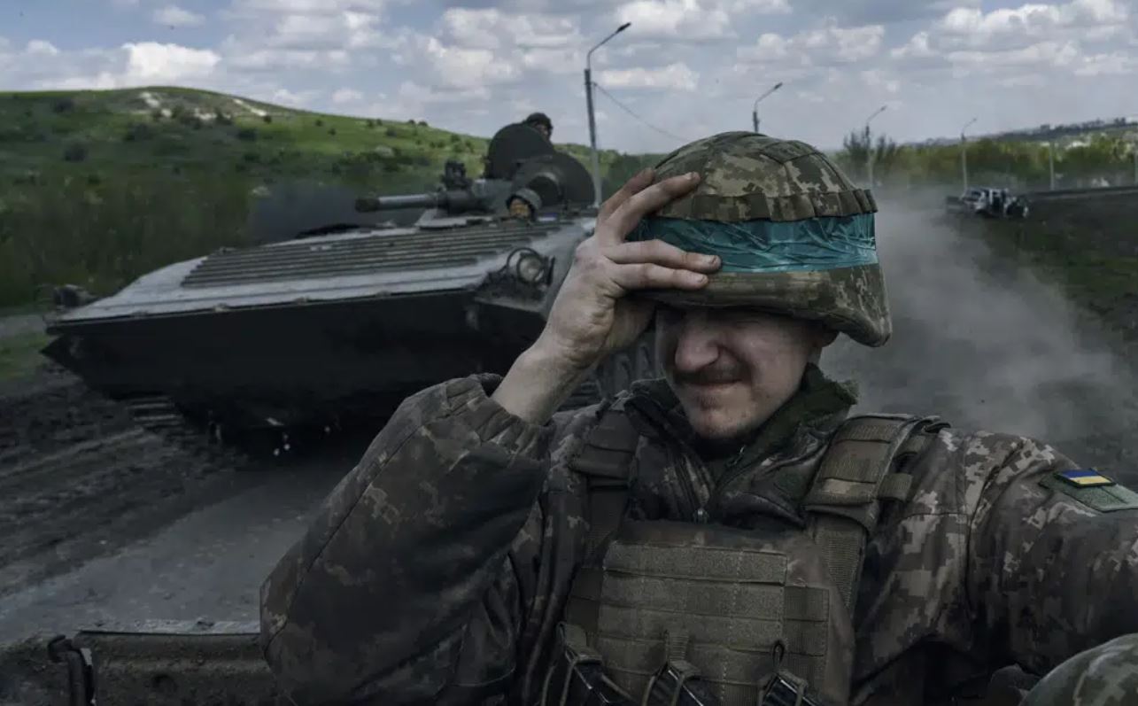 A Ukrainian soldier holds his helmet as he rides an APC in Bakhmut, in the Donetsk region, Ukraine. Photo / AP
