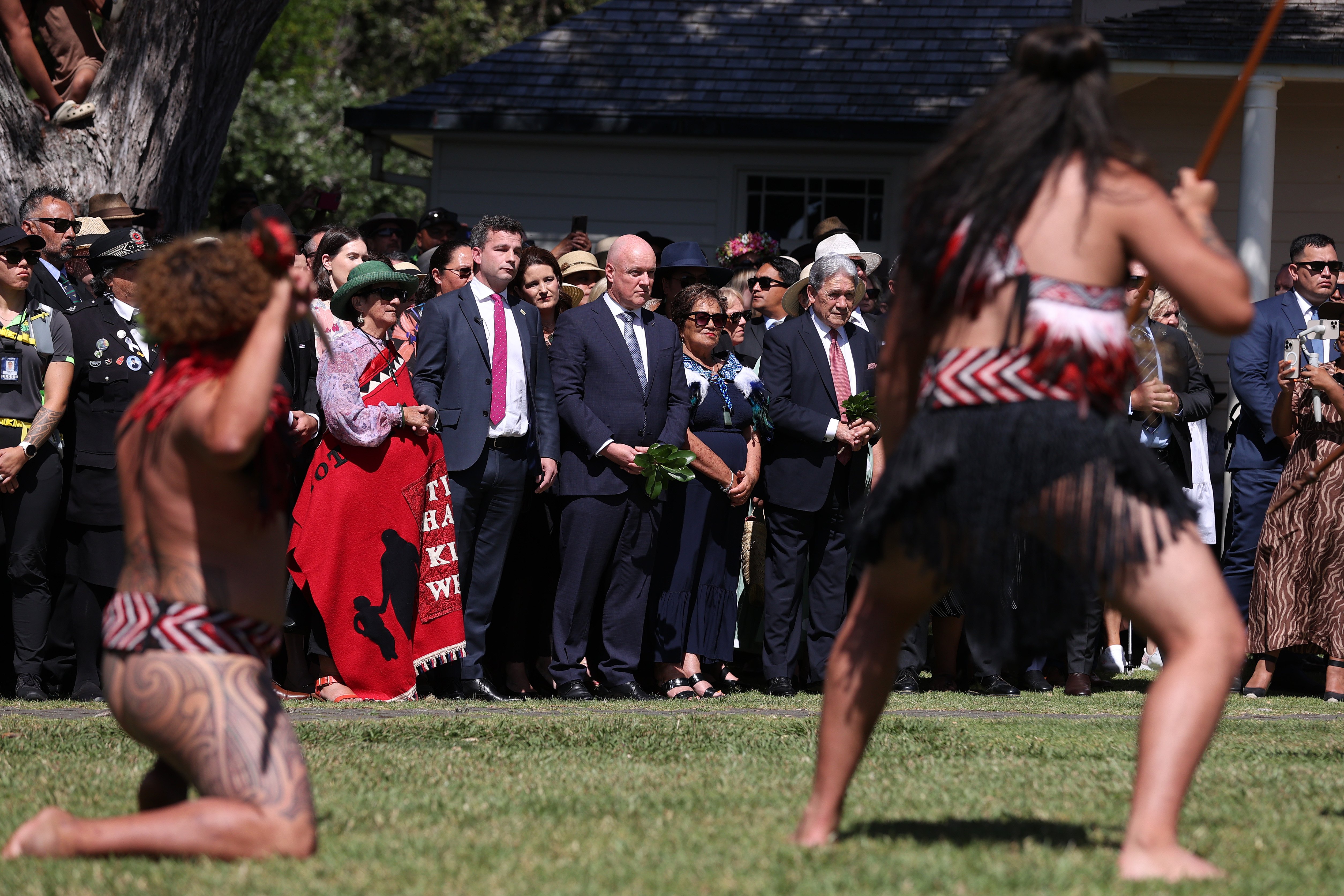 Prime Minister Christopher Luxon (centre), flanked by Act leader David Seymour (left) and New Zealand First leader Winston Peters (right), being welcomed onto the Treaty Grounds at Waitangi in 2024. Photo / Getty Images