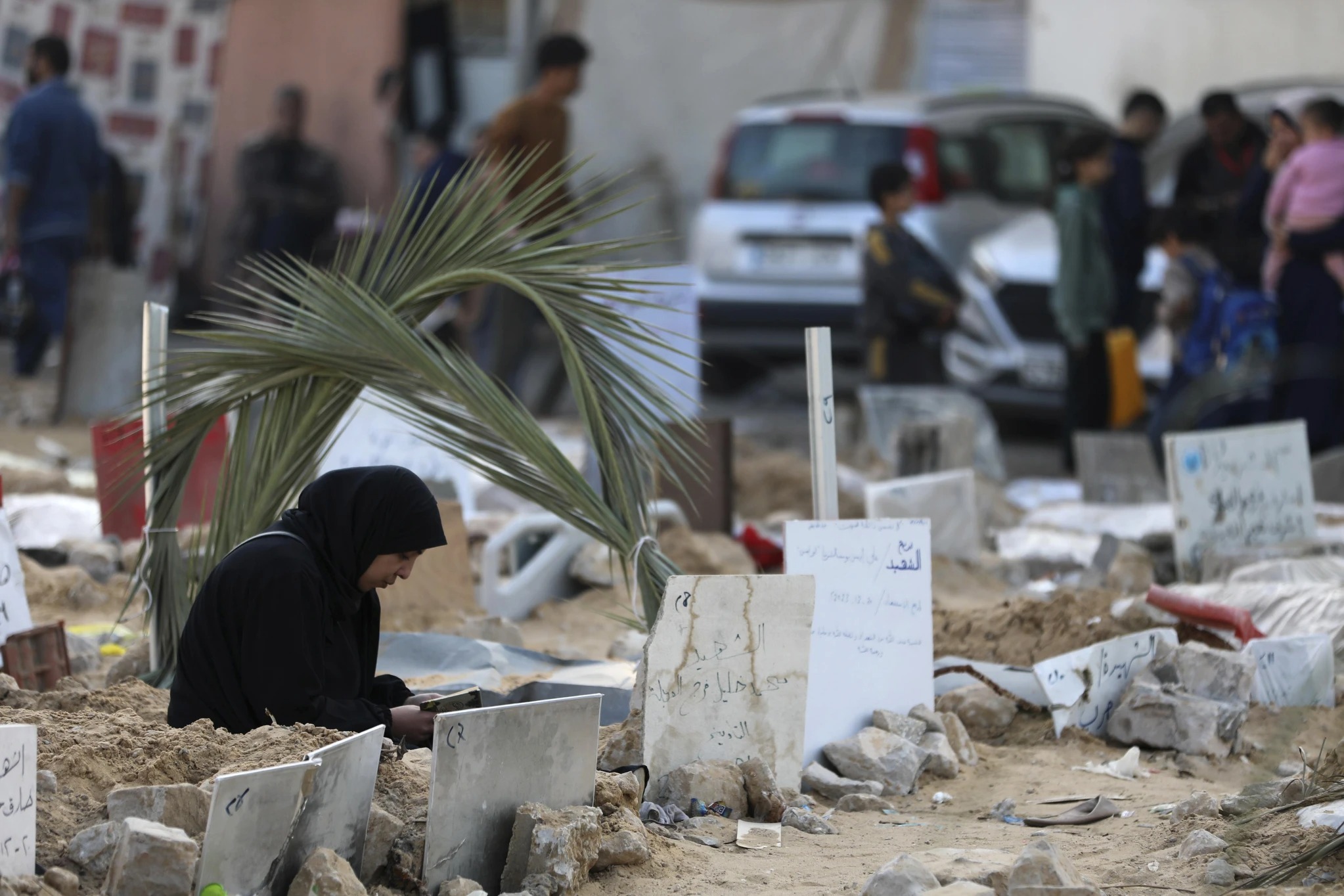 Palestinians visit the graves of people killed in the Israeli bombardment of the Gaza Strip and buried inside the Shifa Hospital grounds in Gaza City. Photo / AP 