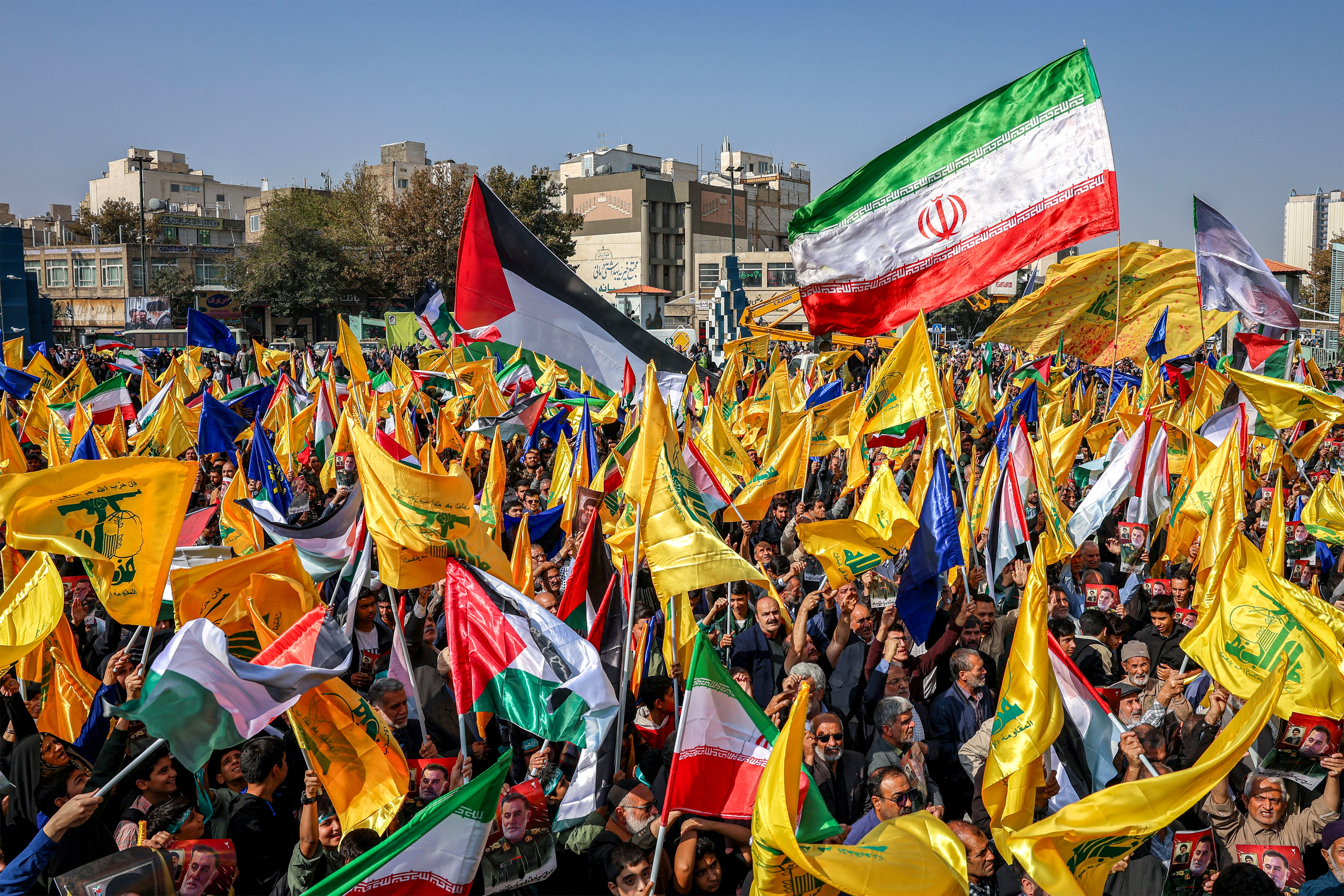 Mourners wave flags of Iran, Palestine, and Hezbollah during the funerary procession of Abbas Nilforoushan, the slain commander of Iran's Islamic Revolutionary Guards (IRGC) who was killed in an Israeli air strike on Beirut's southern suburbs in late September, in Mashhad in southern Iran on October 16, 2024. Photo / AFP