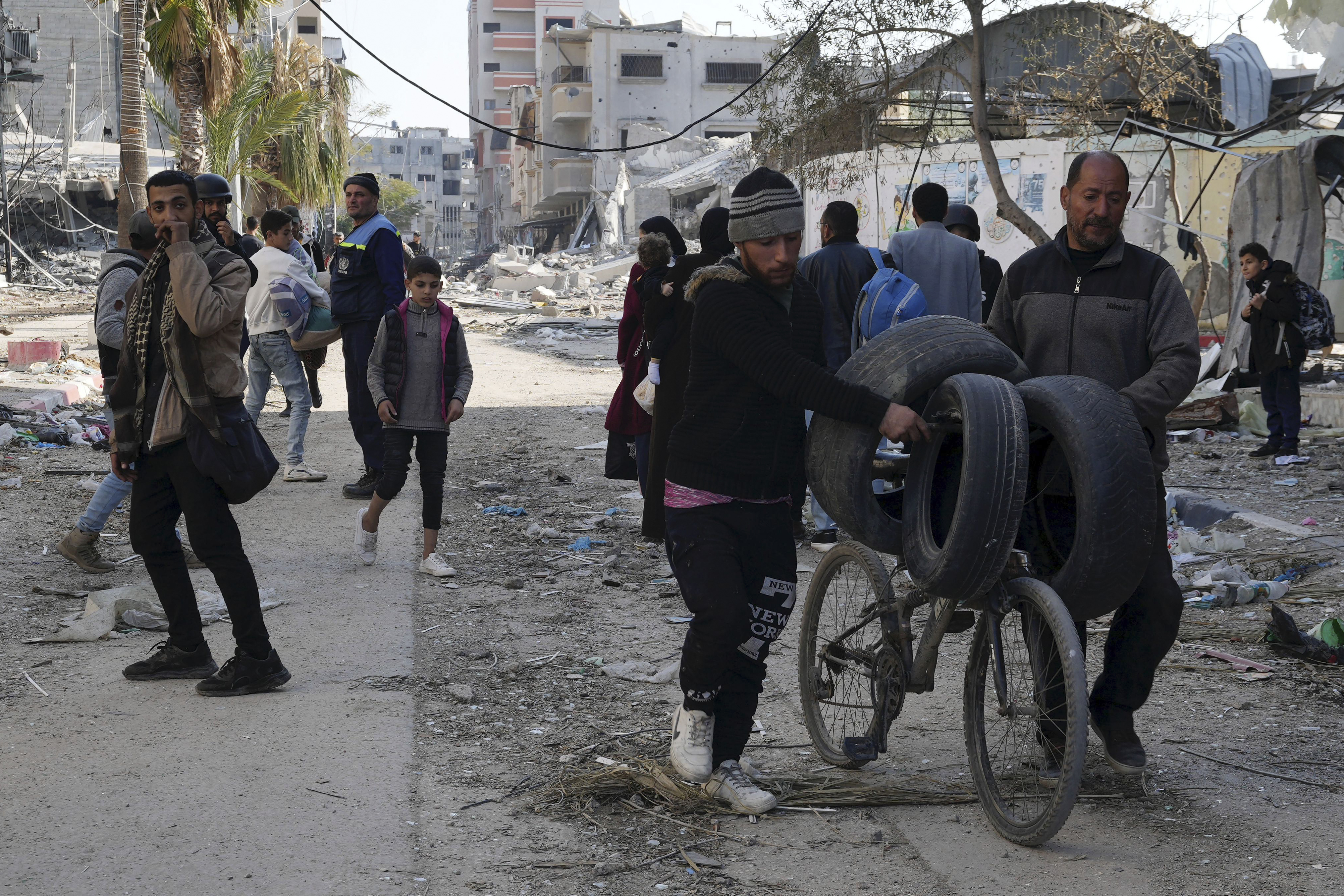 Palestinians walk through destruction by the Israeli bombardment in the Nusseirat refugee camp in Gaza Strip. Photo / AP