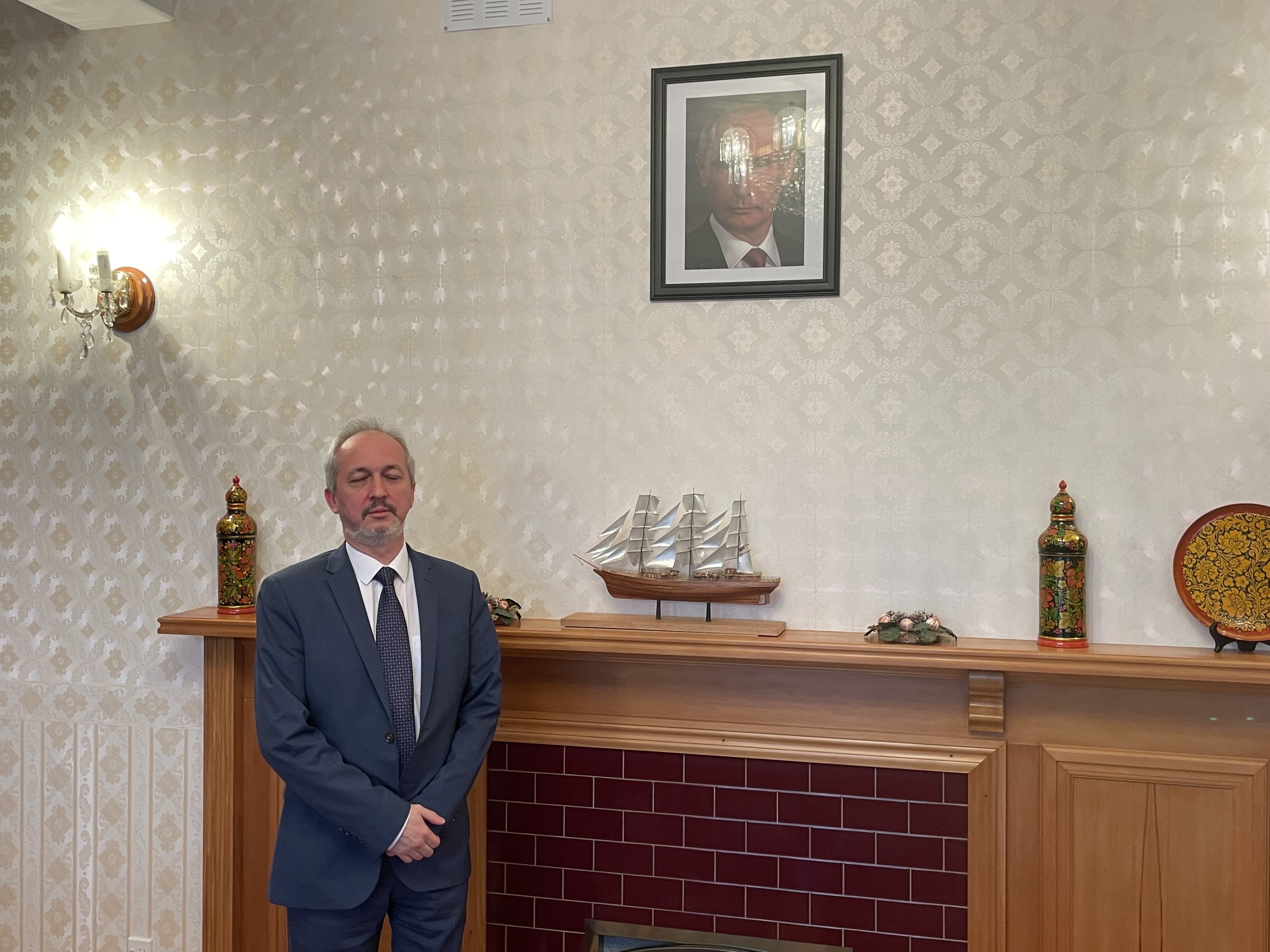 Ambassador Stanislav Krans in the Russian Embassy's dining room, with a portrait of President Vladimir Putin above the mantelpiece. Photo / Thomas Coughlan