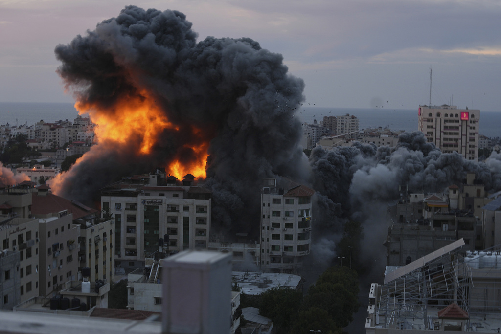 Fire and smoke rise from an explosion on a Palestinian apartment tower following an Israeli air strike in Gaza City. Photo / AP