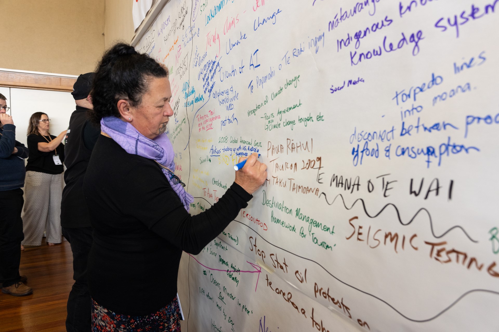 Hilda Harawira writes on the timeline wall.