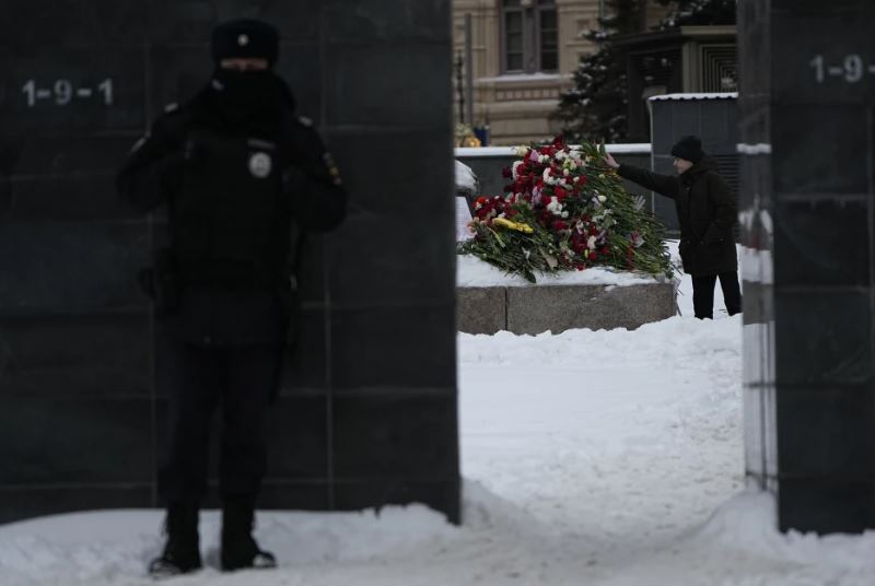 A policeman guards as a young man lays flowers paying the last respect to Alexei Navalny. Photo / AP Photo