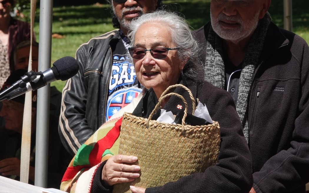 Whangaroa claimant Pat Tauroa, holding the report in a flax kete, challenges tribunal members to give a copy to the new Prime Minister Christopher Luxon.