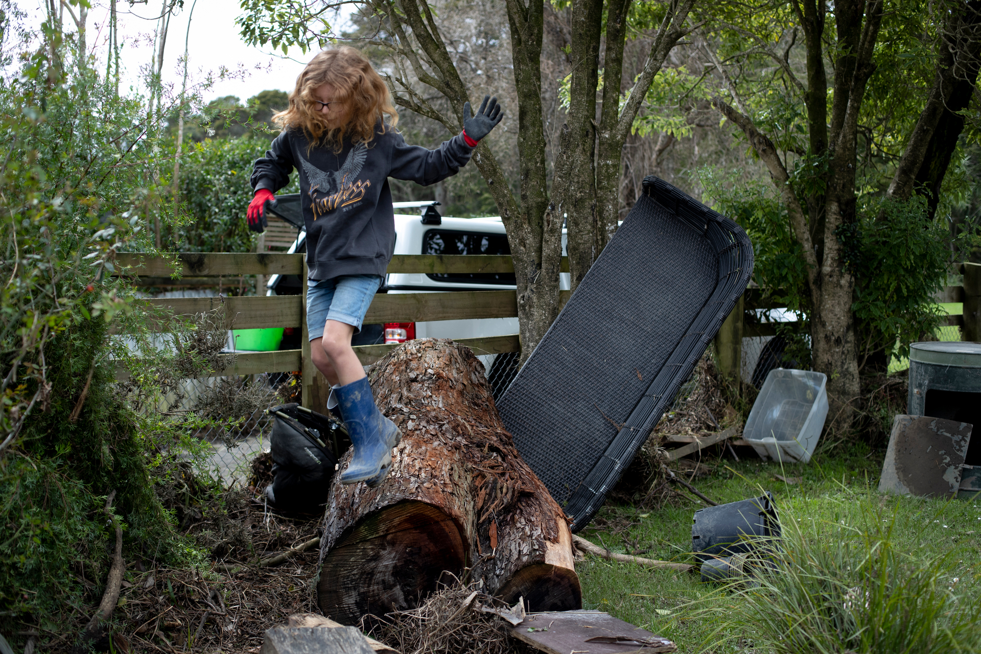 Gala Springford-Miller, 9, jumps off a log that was washed through their yard. Photo / Dean Purcell