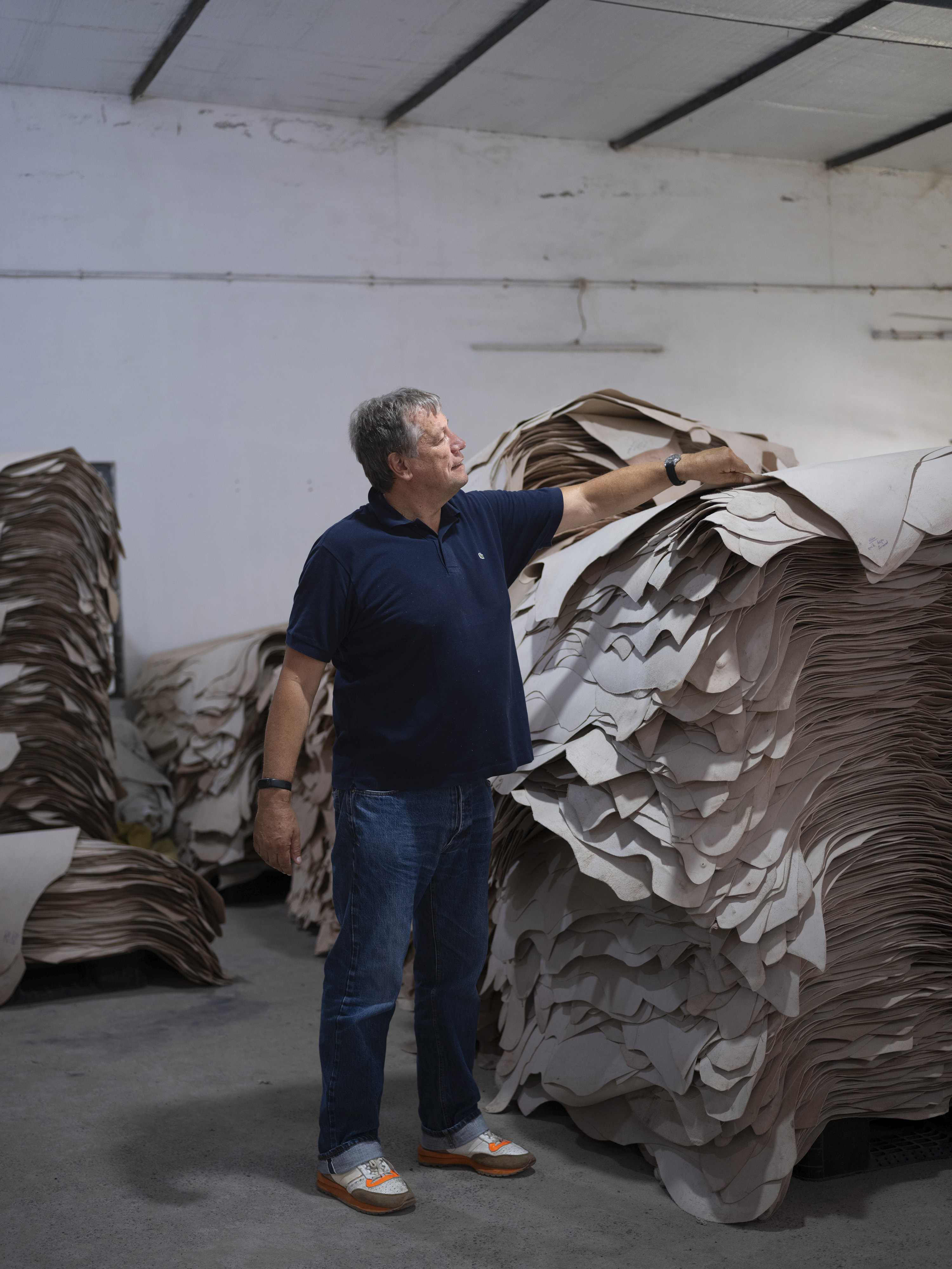 Wright, left, with hides used to make his brand’s bags, a process that involves cutting materials into strips, right. Photo / Priyadarshini Ravichandran, The New York Times