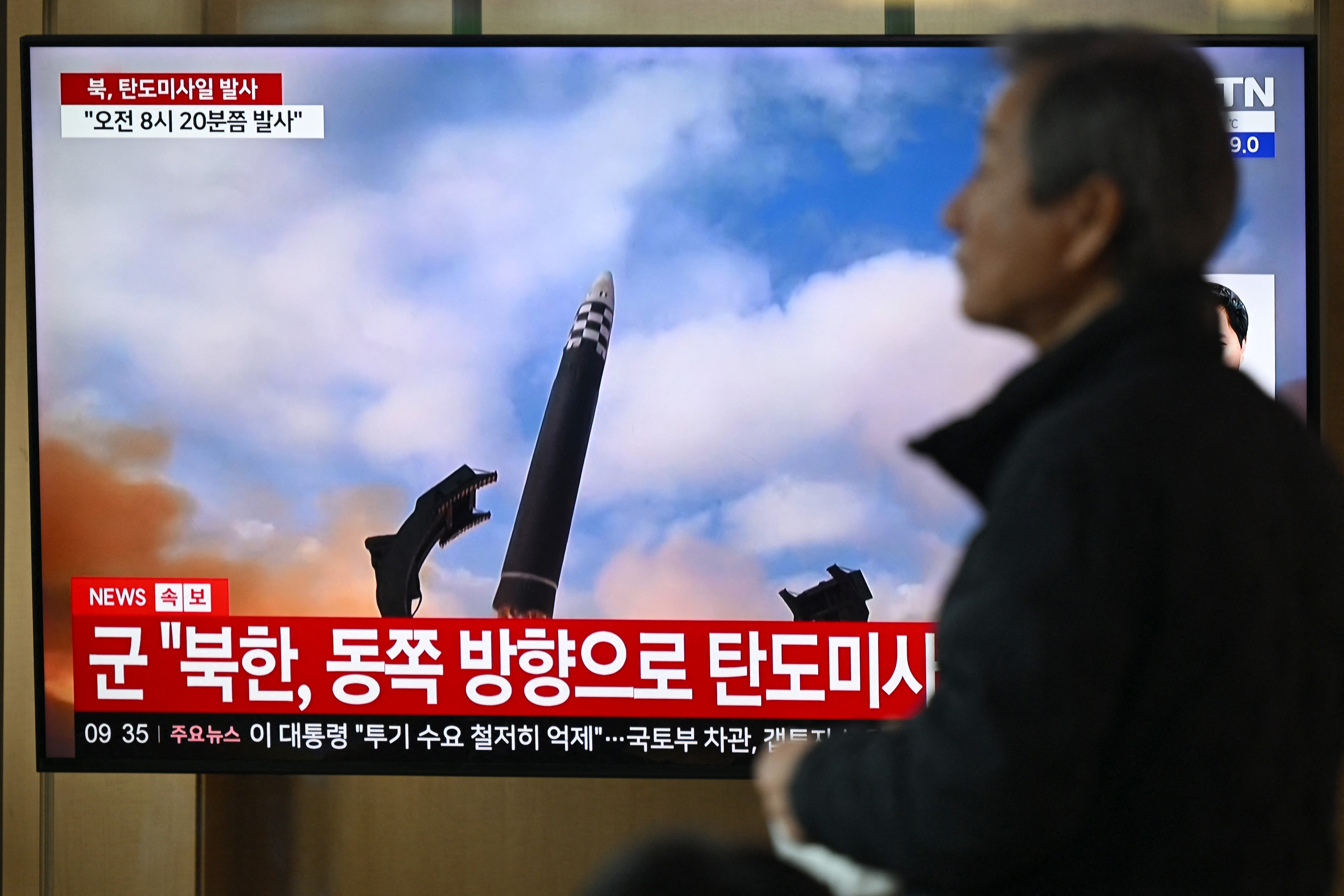A man walks past a television screen showing a news broadcast with file footage of a North Korean missile test, at a train station in Seoul today. North Korea fired several ballistic missiles. Photo / Jung Yeon Je, AFP