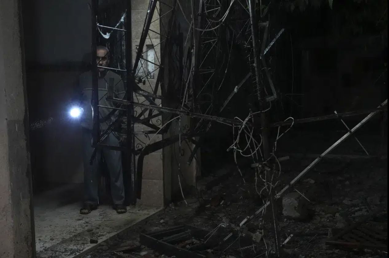 A Palestinian man inspects damage to his family's building following an Israeli airstrike. Photo / AP