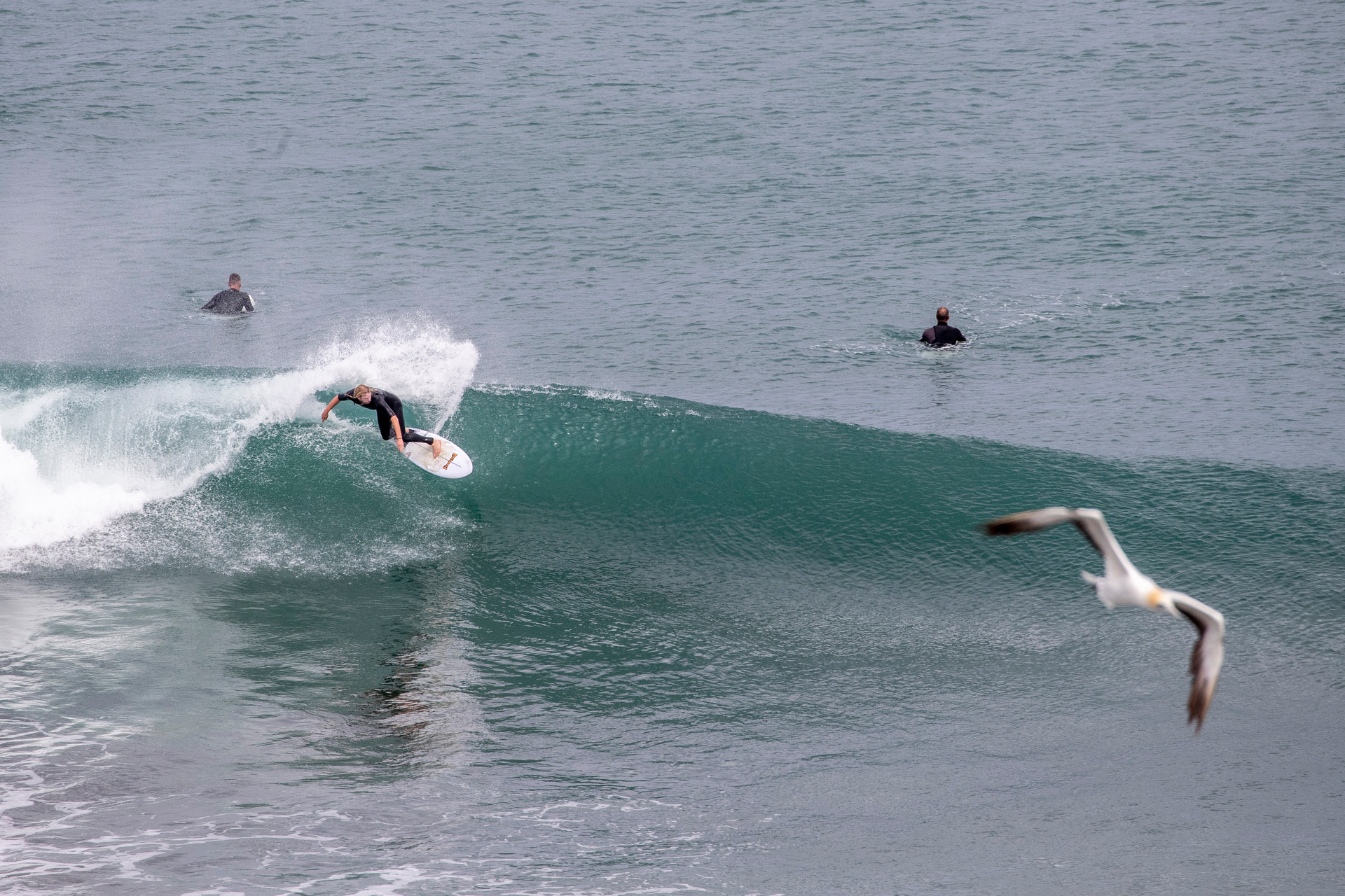 Jet ski fisherman and surfers, Muriwai Beach. Photo / Michael Craig