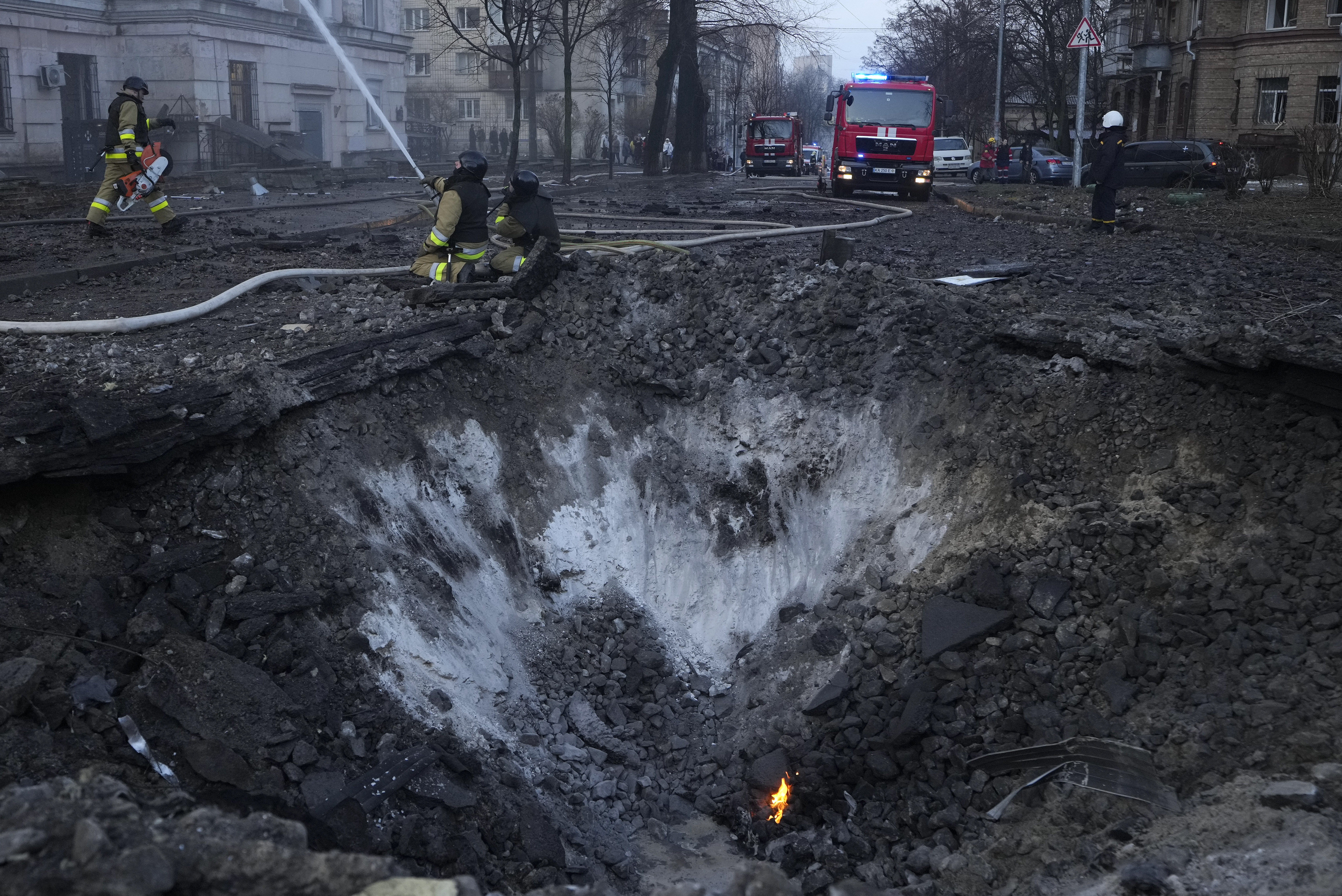 Firefighters work near the crater at the site after a Russian attack in Kyiv, Ukraine. Photo / AP