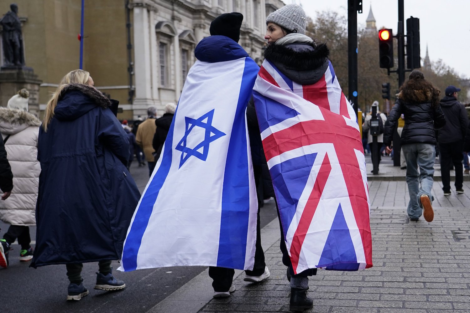 Two protesters wrapped in the flags of Israel and Britain walk along Whitehall. Photo / AP