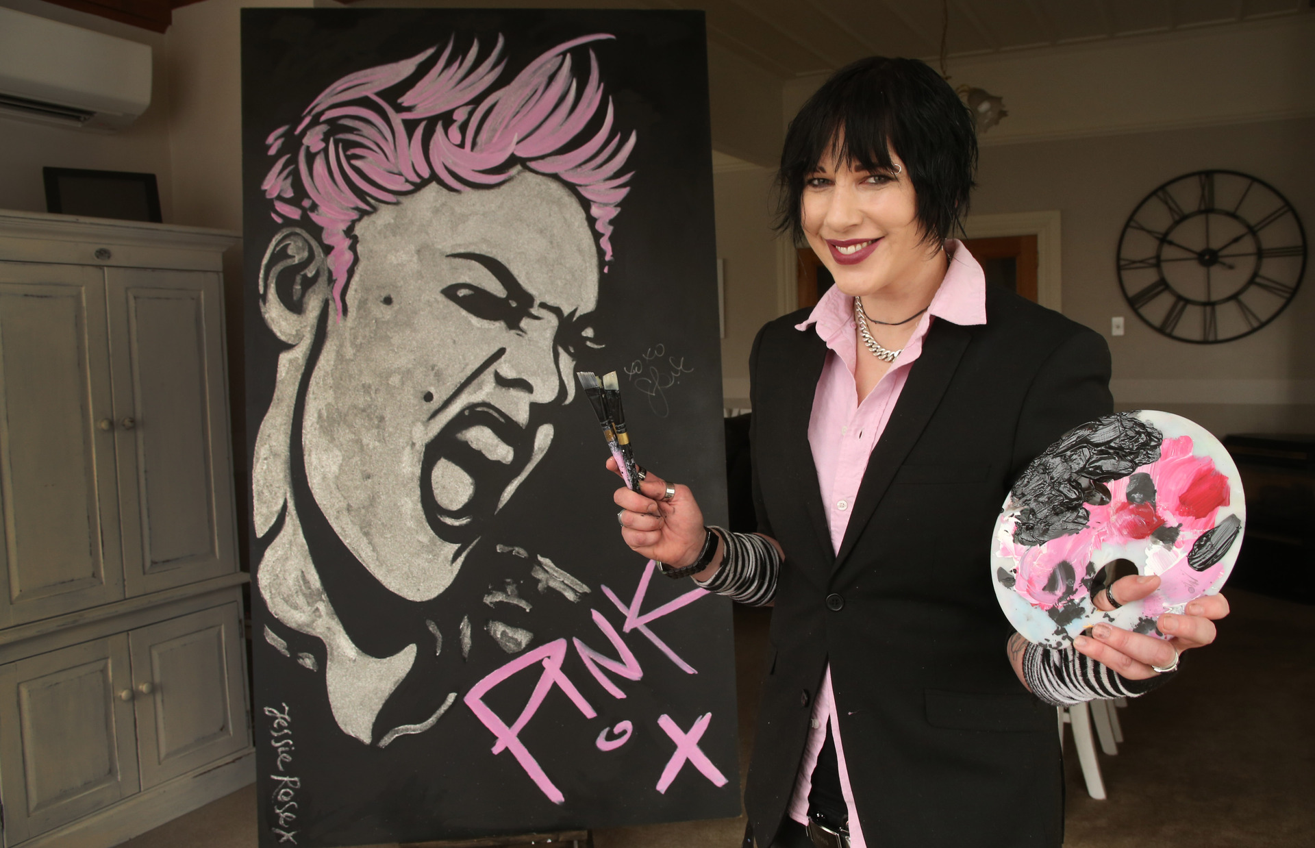 Whangarei artist Jessie Rose with her artwork of Pink signed by the singer that was auctioned on Trade Me to raise funds for Kids Can New Zealand in 2018. Photo / John Stone