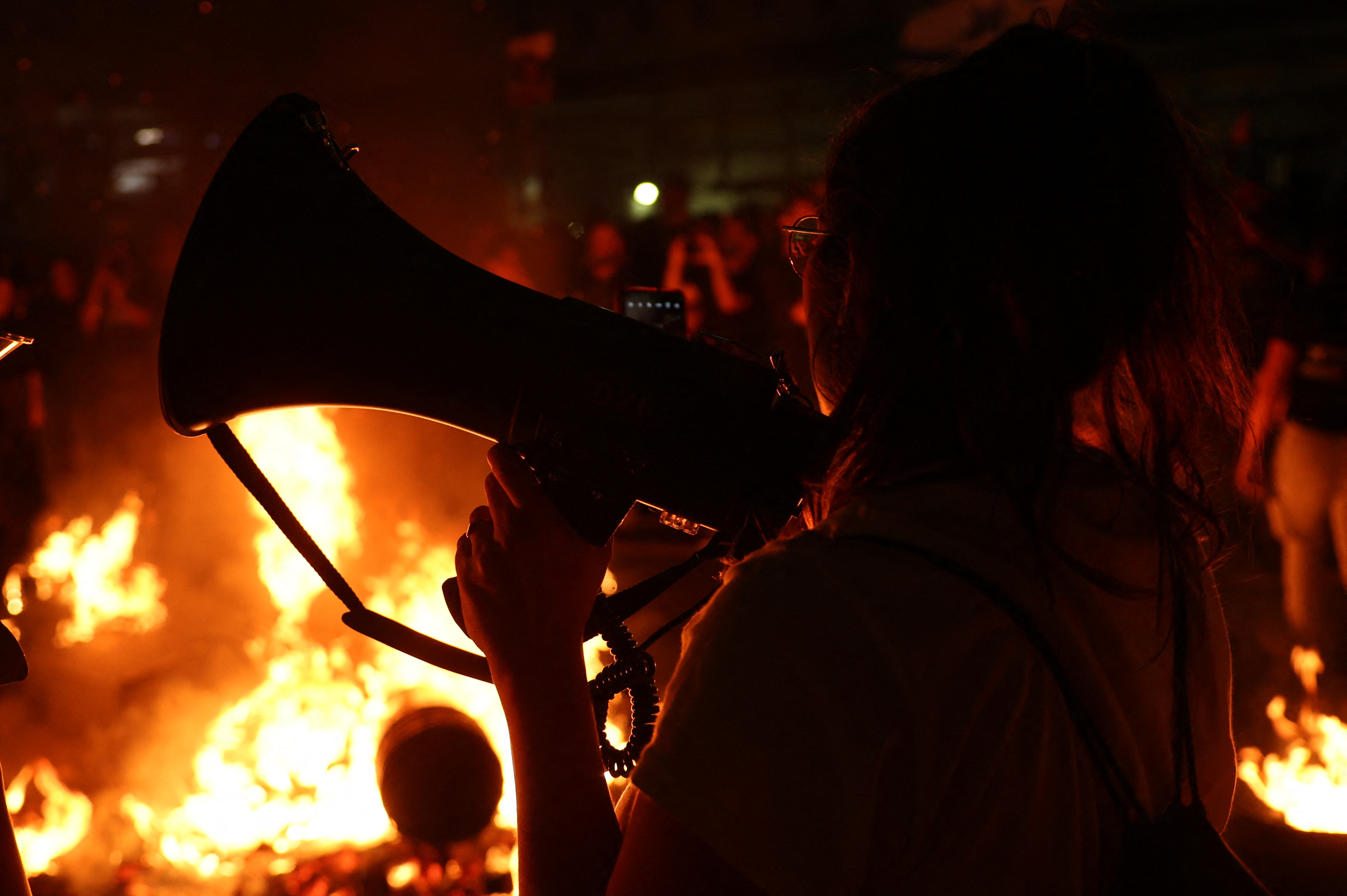 Israeli protesters set a fire as they block a road in Tel Aviv after the dismissal of the defence minister. Photo / AFP