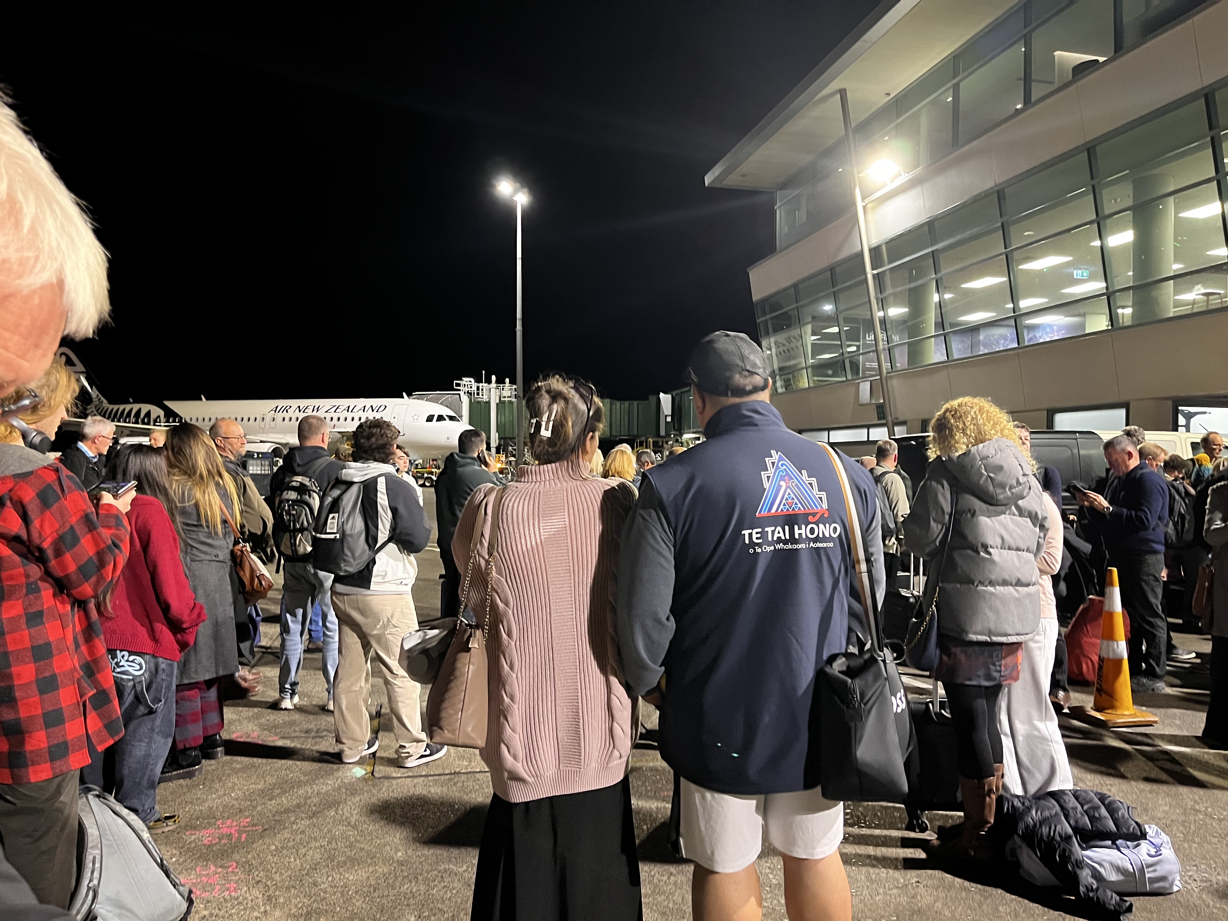 Evacuated passengers on the tarmac at Wellington Airport after a fire.