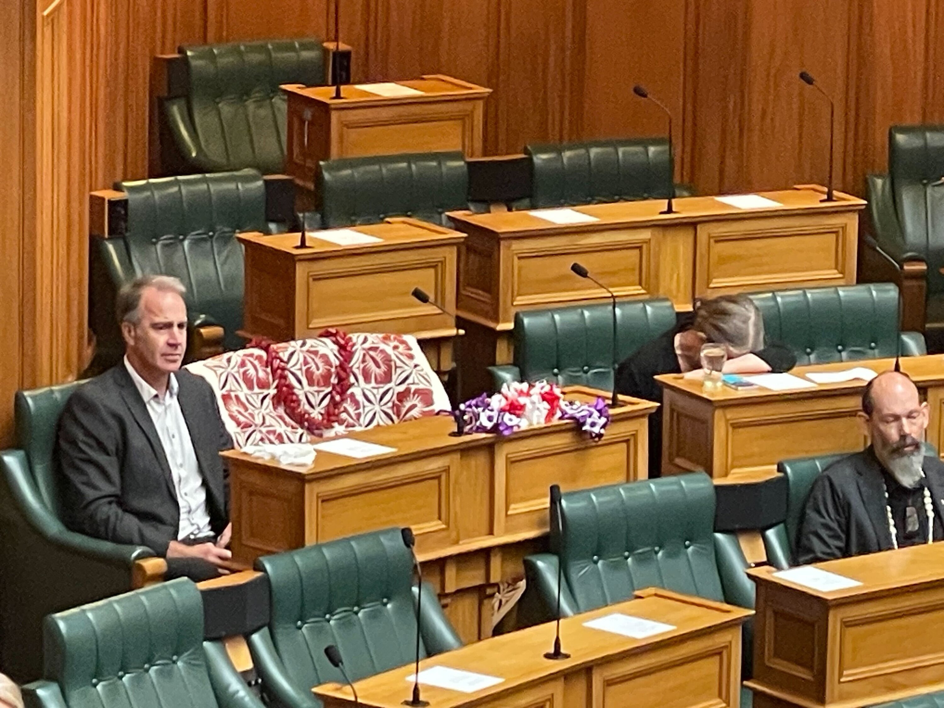 The empty seat of Green Party MP Efeso Collins in the debating chamber at Parliament. MP Celia Wade-Brown can be seen crying at the right of the frame. Collins died during a charity event in Auckland this morning. Photo / Thomas Coughlan  