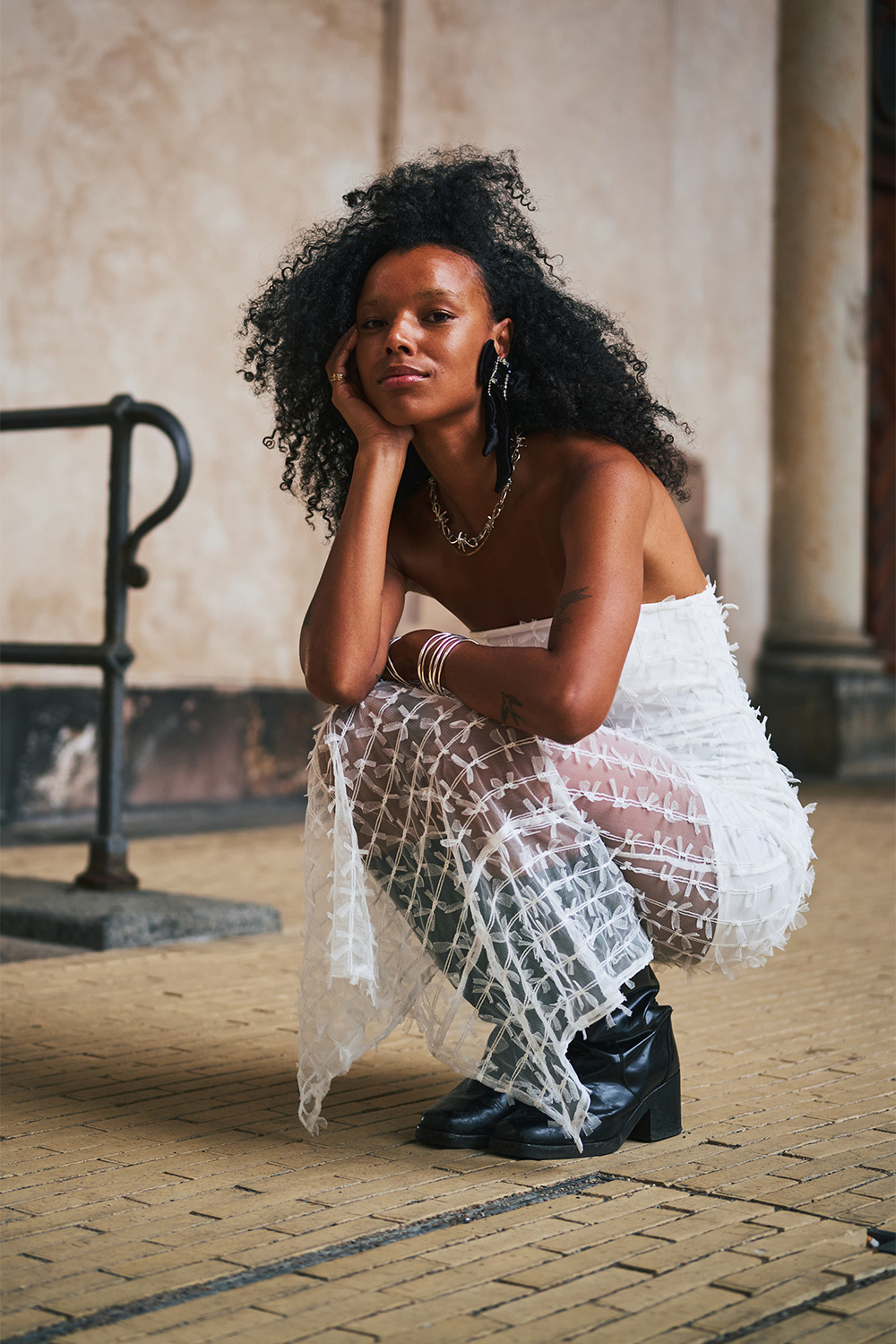 Black bow earrings echo smaller white bows dotting this dress. Photo / Simbarashe for The New York Times