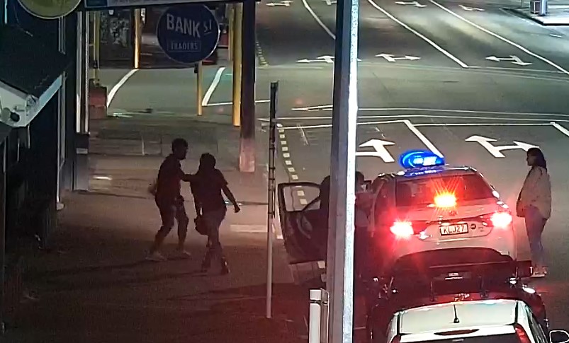 Jamie Lawry is pushed by the man in the burgundy shirt (at left) as he attempts to calm him.
