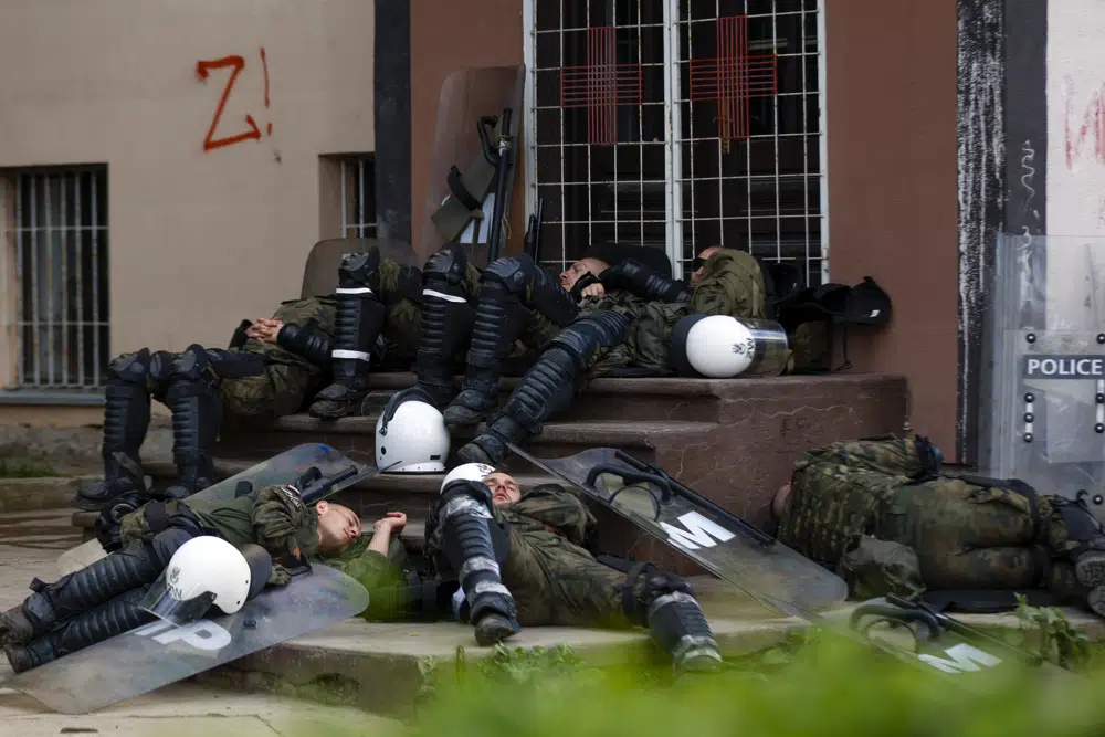 Polish soldiers, part of the peacekeeping mission in Kosovo KFOR, rest in front of a municipal building. Photo / AP