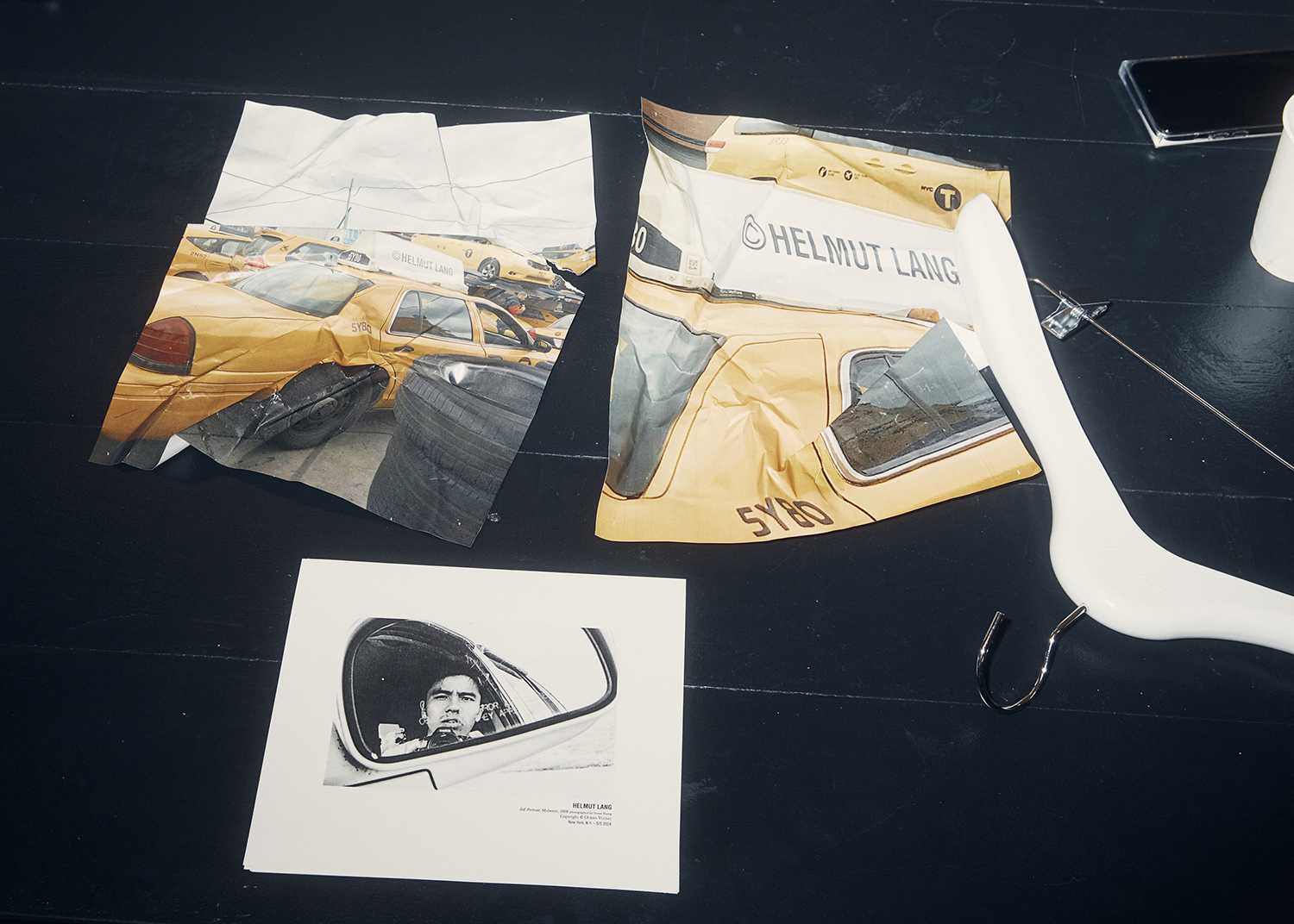 Photos of taxicabs on which Helmut Lang used to advertise, on a table during a fitting at Peter Do's studio in New York. Cars are a theme in Do's first collection. Photo / Erik Tanner, The New York Times