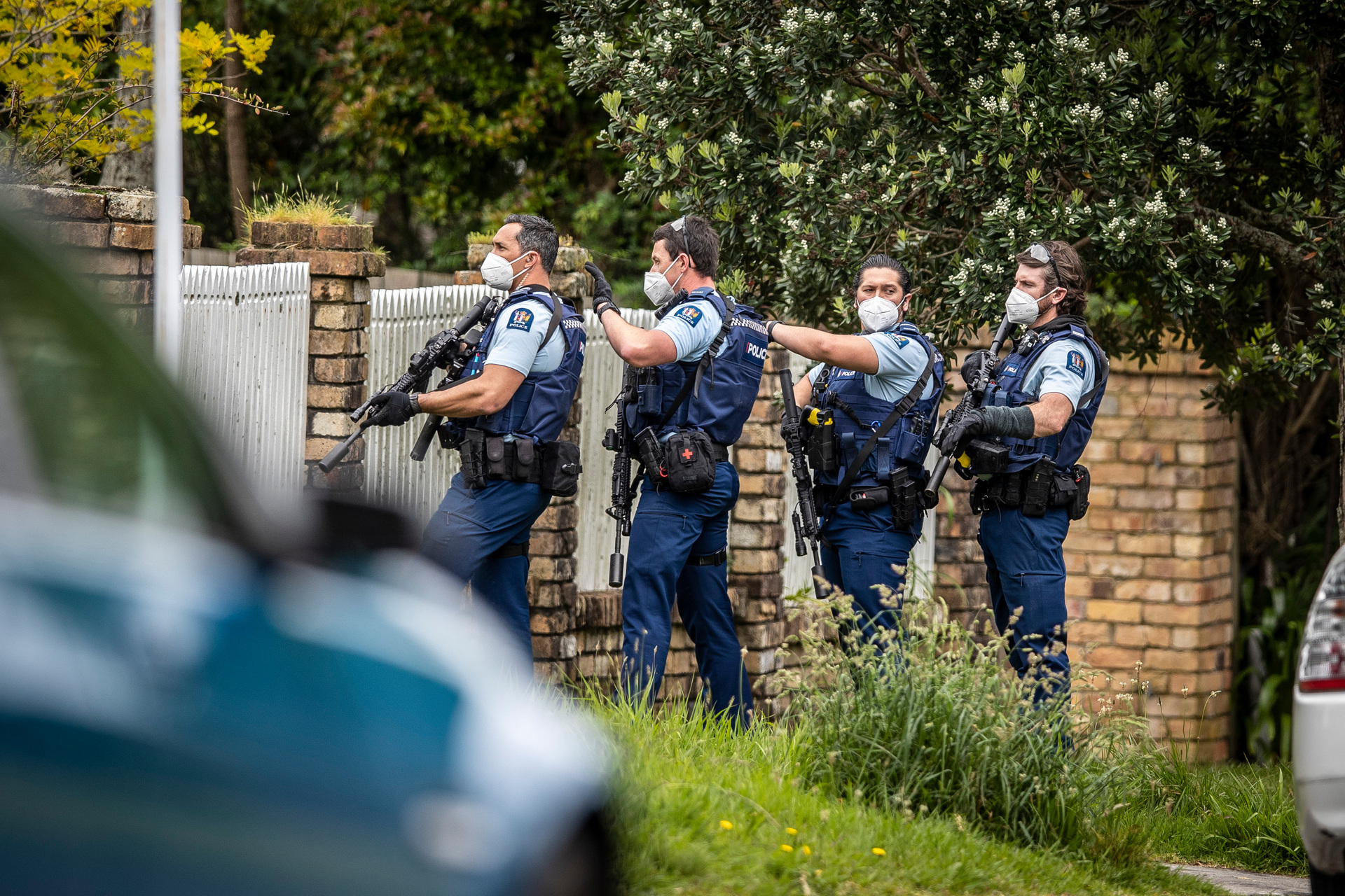 Armed police approach a Cliffview Rd, Green Bay, property after an earlier homicide at the New Haven Motel in New Lynn. Photo / Michael Craig