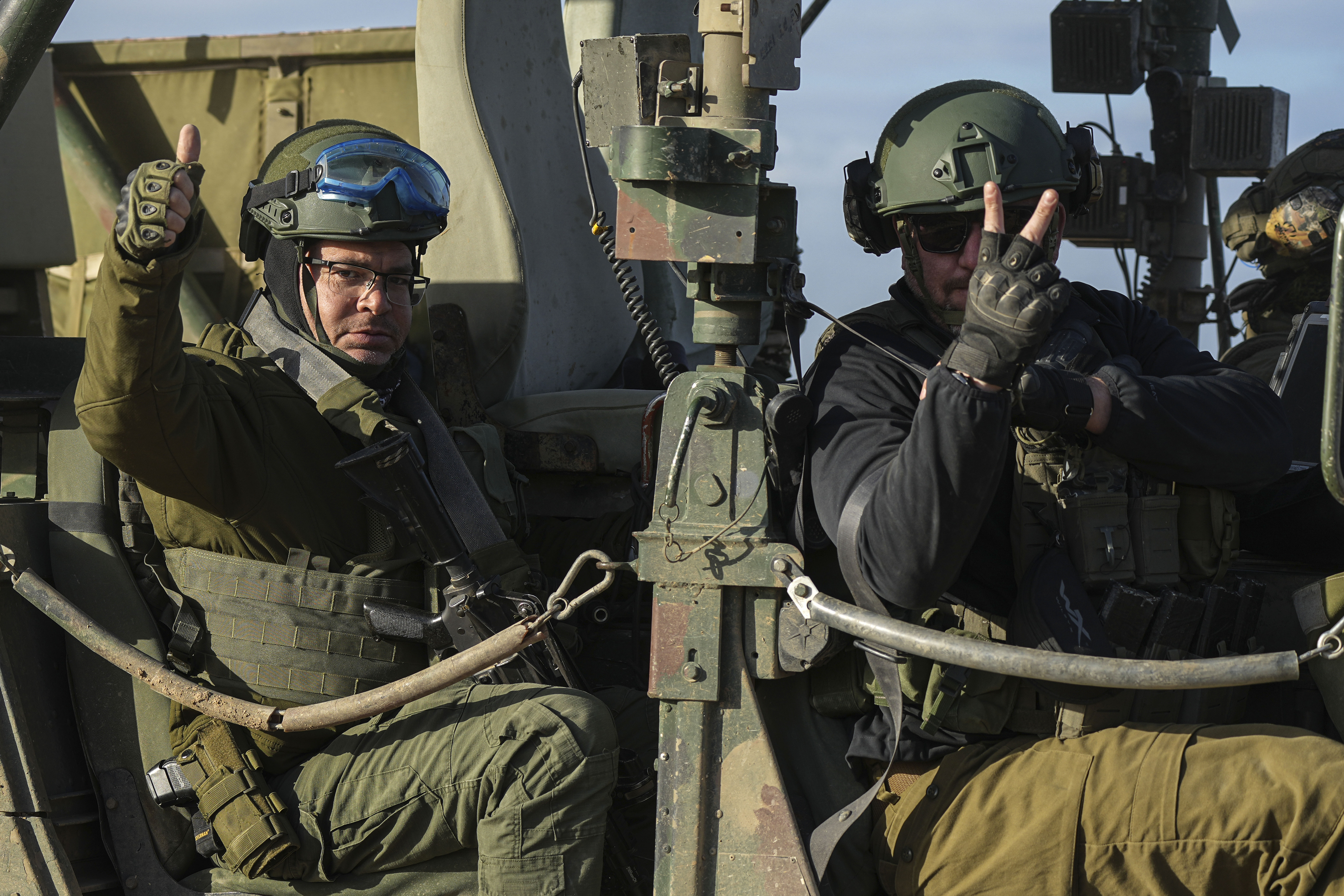 Israeli soldiers wave from their vehicle on the way back from the Gaza Strip, in southern Israel, near the Gaza border. Photo / AP