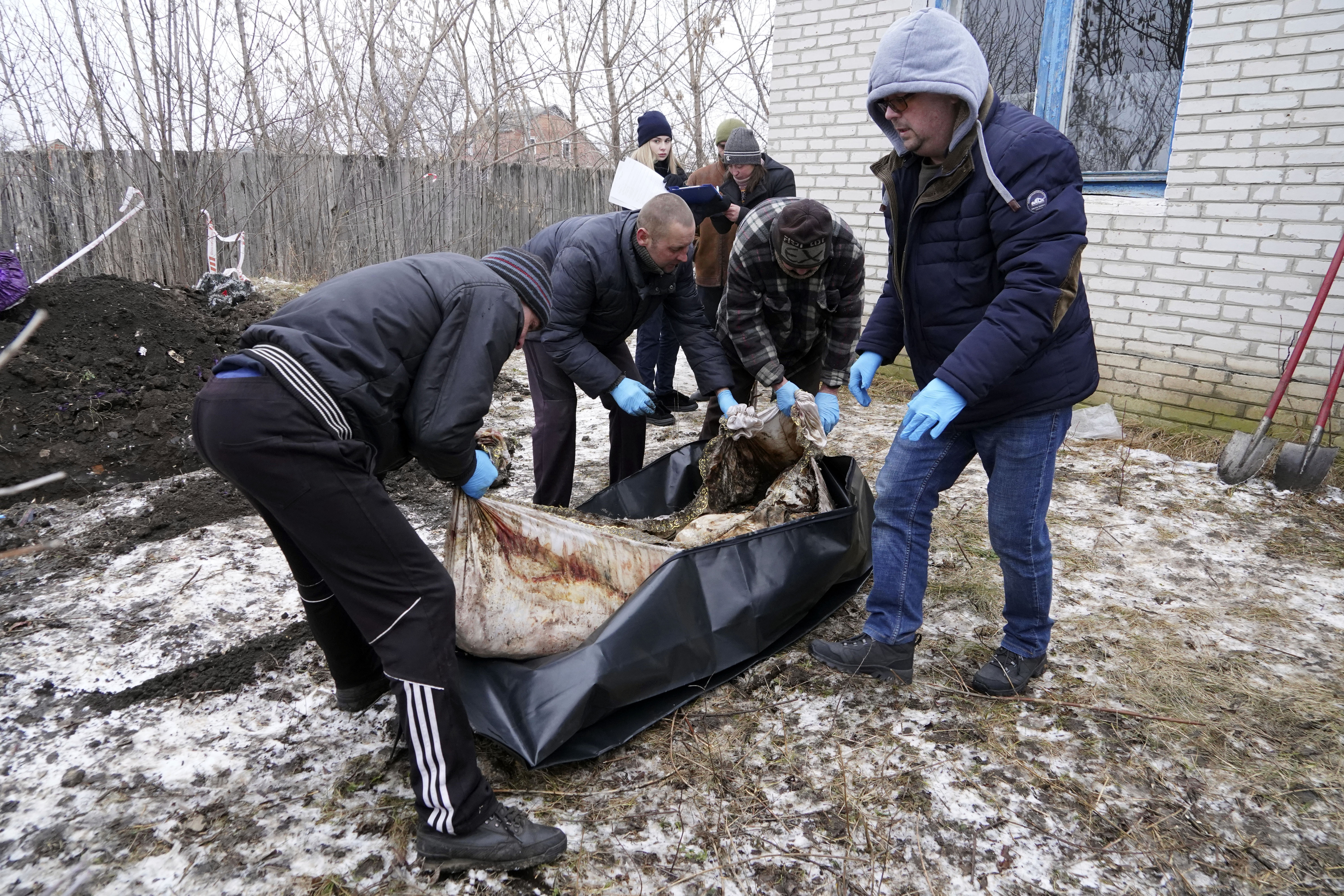 Funeral workers carry the body of Svitlana Shabanova, who was killed by Russian forces during evacuation on April 14, 2022. Photo / AP