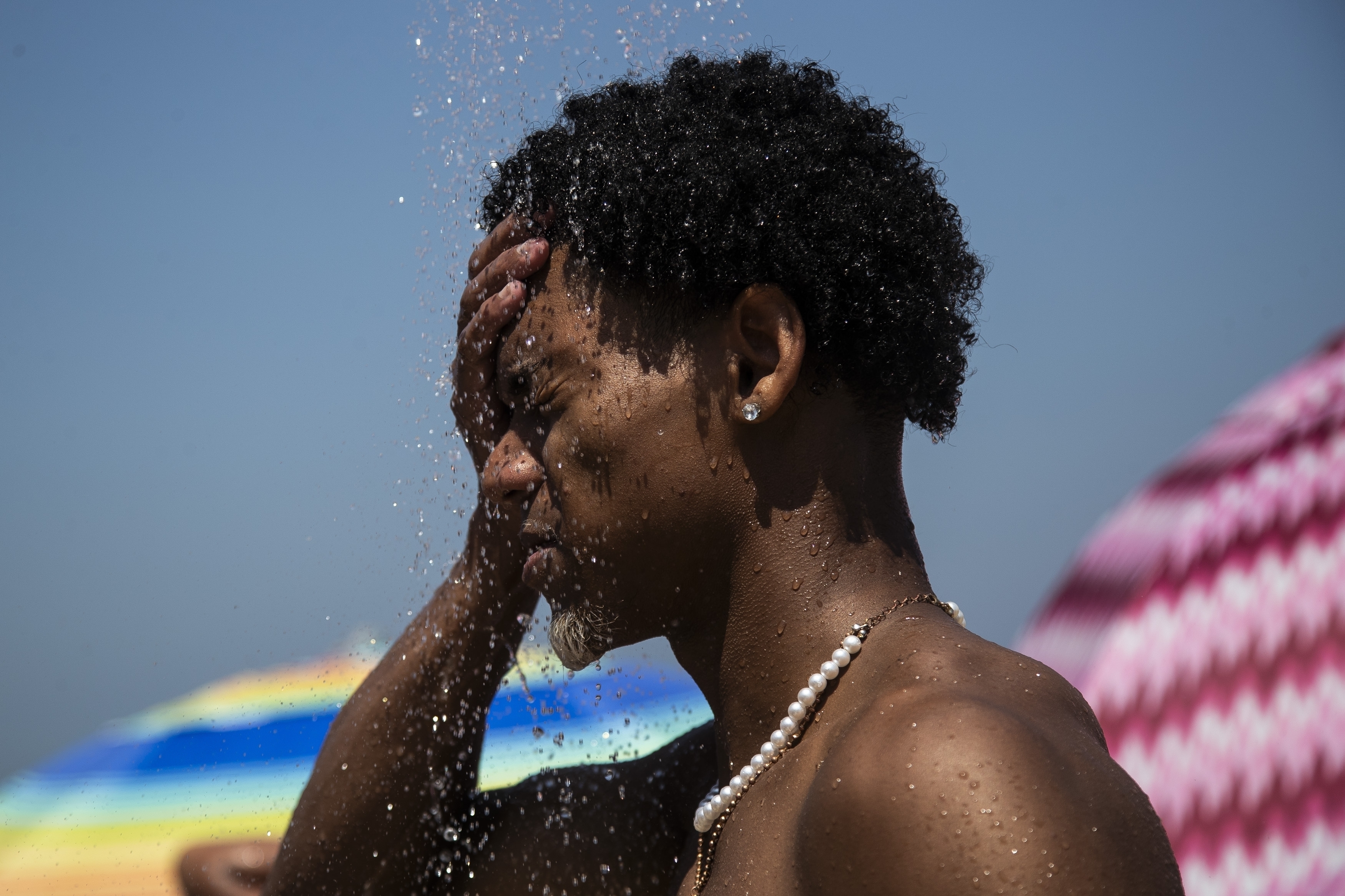 A man cools off in a shower at Ipanema beach, Rio de Janeiro. Photo / AP