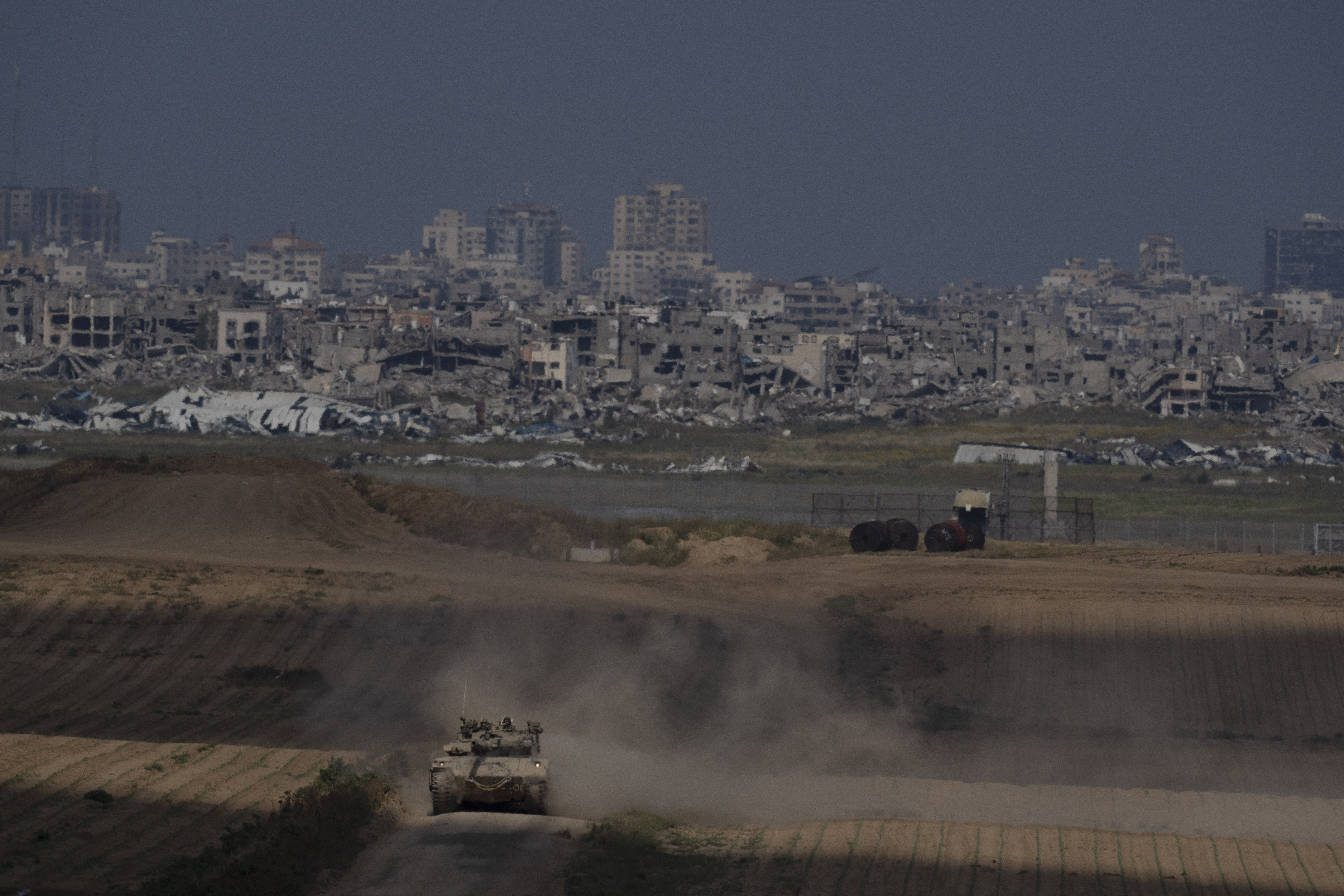 Israeli soldiers move on the top of a tank near the Israeli-Gaza border, as seen from southern Israel. Photo / AP