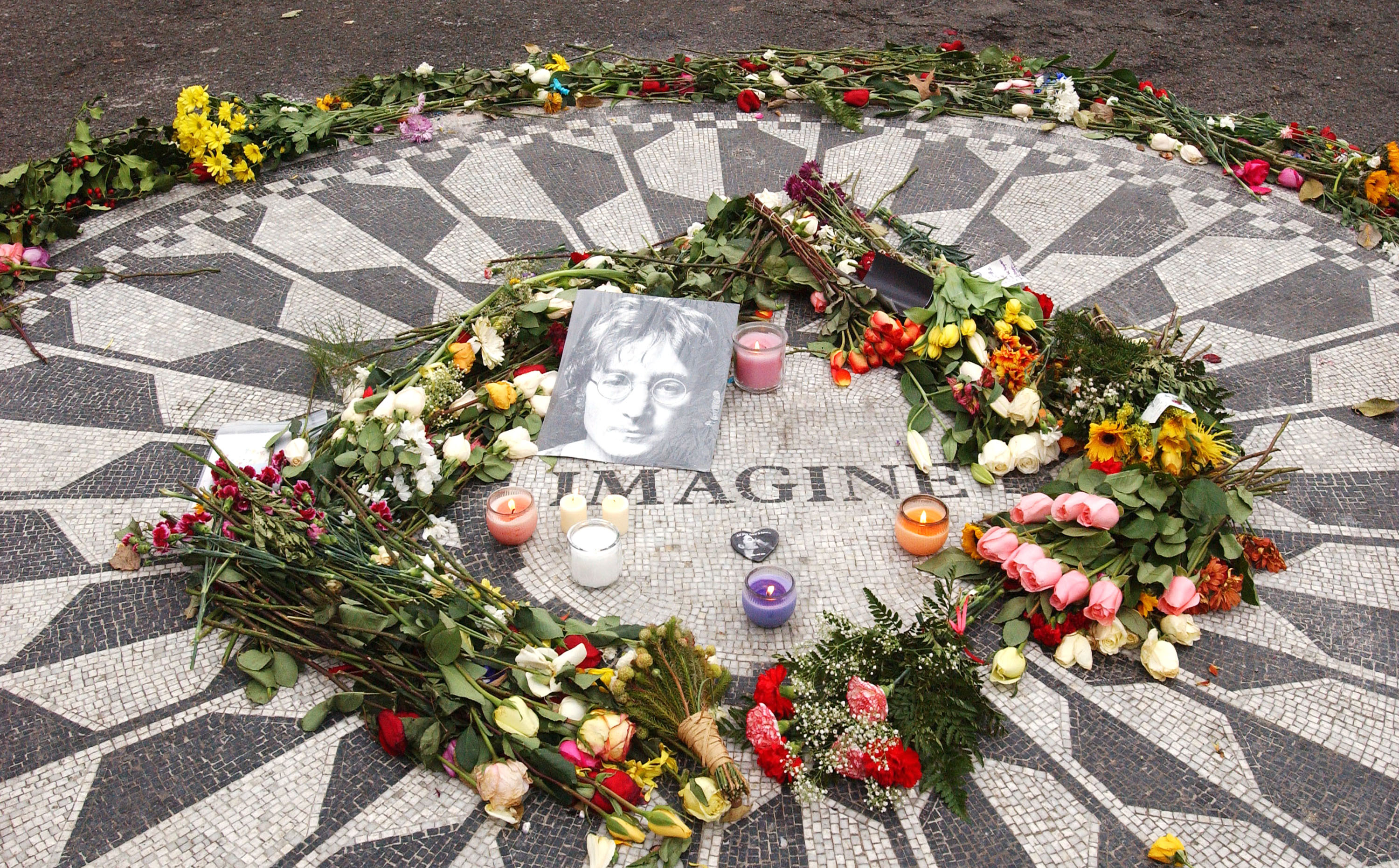 Flowers and a photo of John Lennon, lie at the Strawberry Fields memorial on December 11, 2005 in New York City. Lennon was shot and killed on December 8, 1980 outside his home, The Dakota, in New York City. (Photo / Arnaldo Magnani / Getty Images